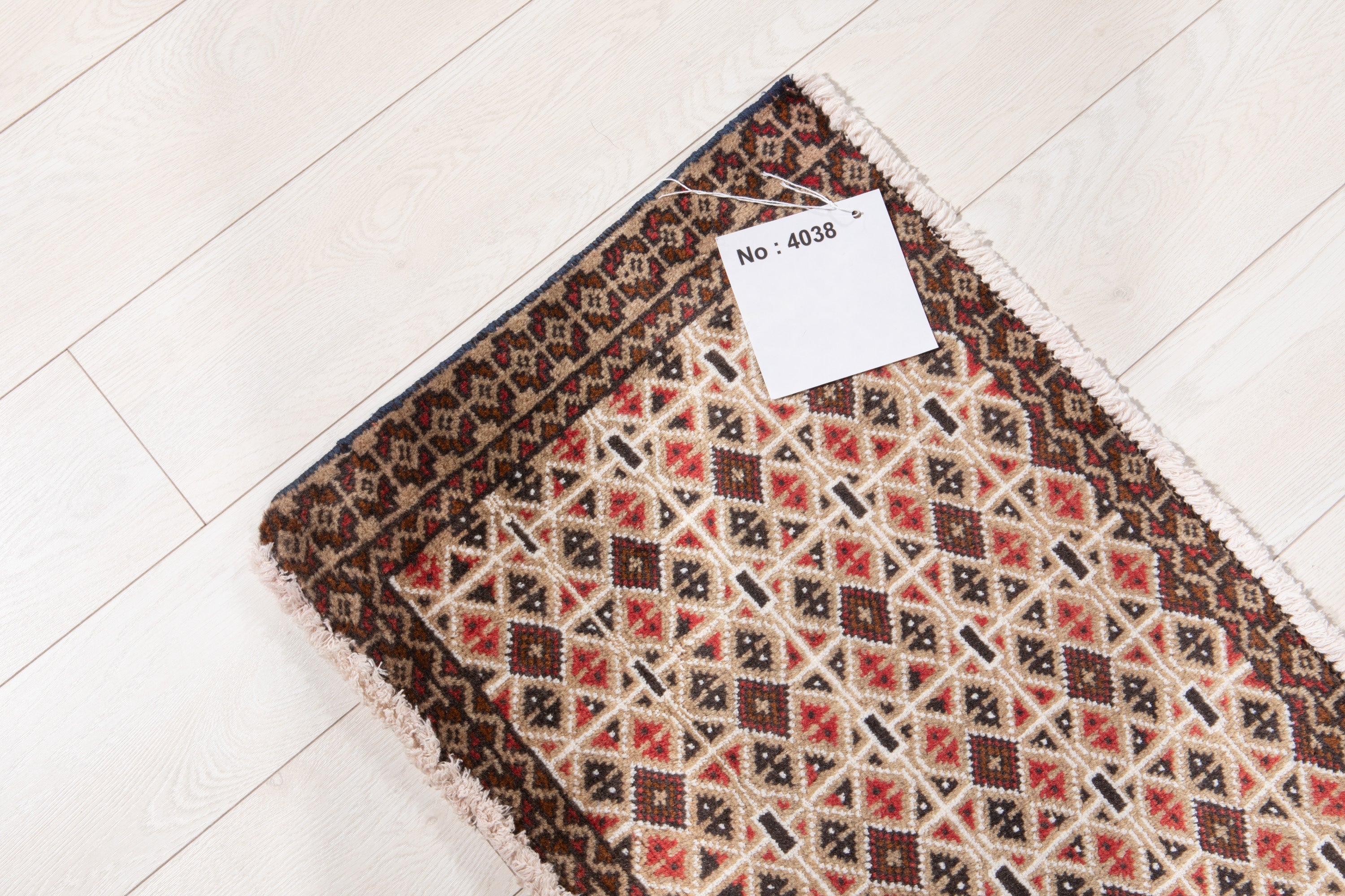 Full rug view from above with an attached inventory tag showing its rug number.