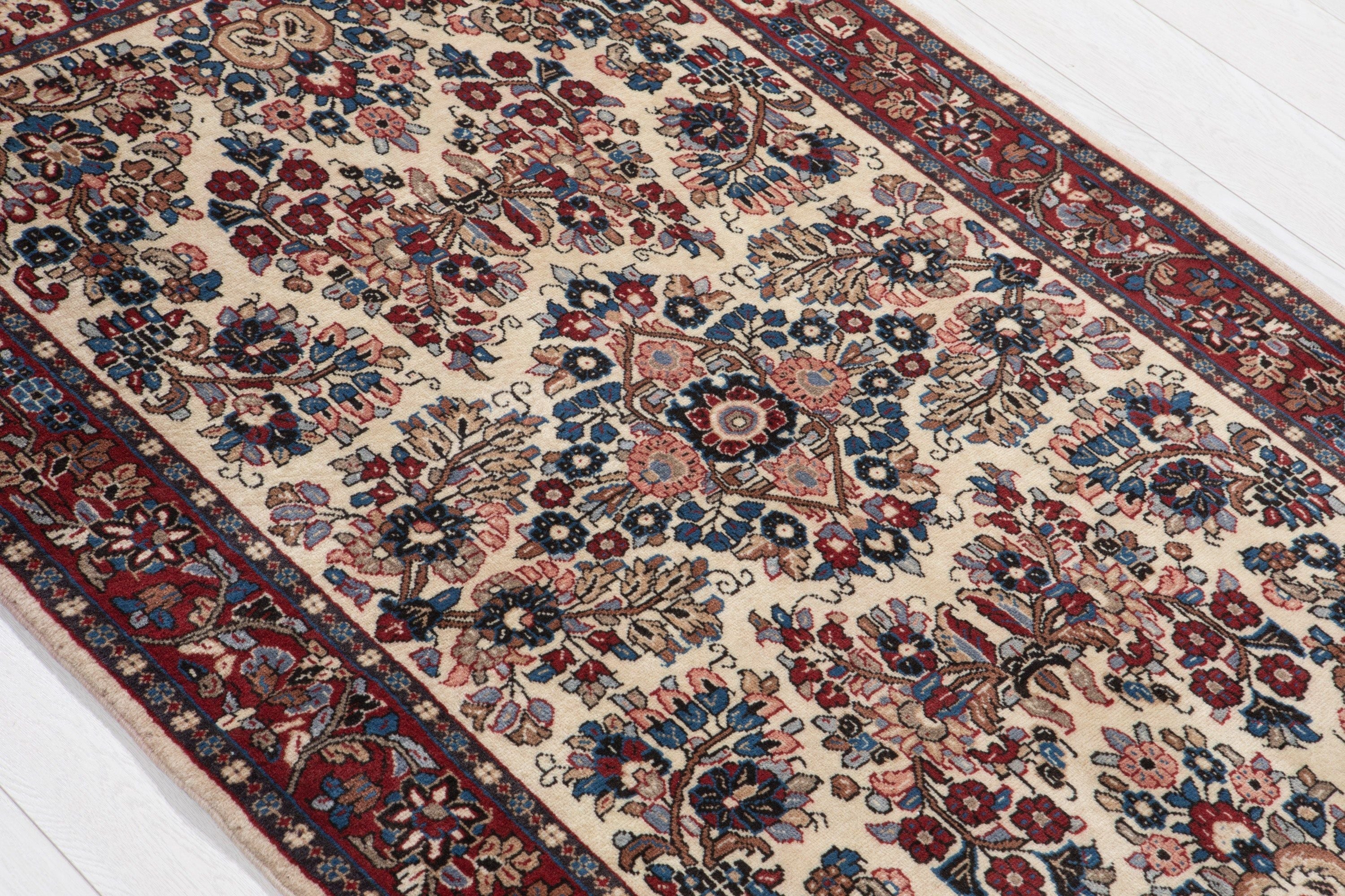 Diagonal close view of the rug's floral pattern and border stretching across its width.