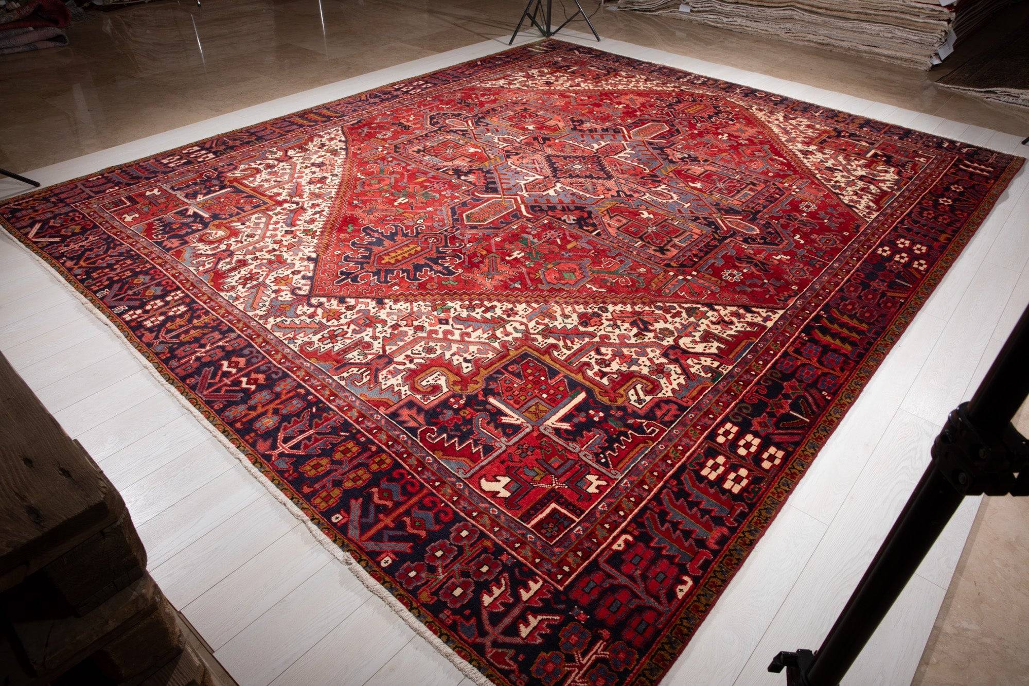 Angled view of the full rug in a warehouse, showing the diamond medallion and border.