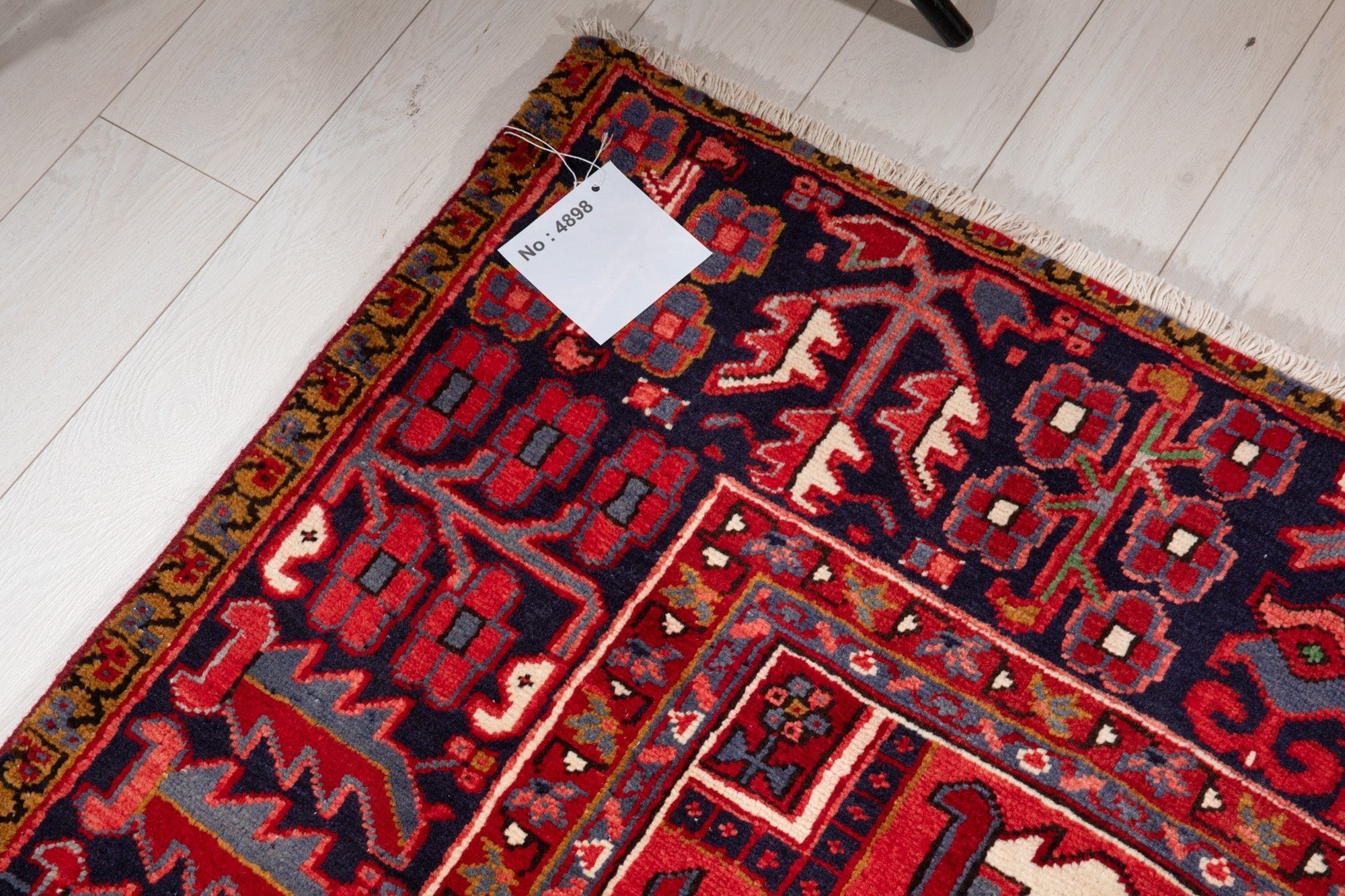 Corner of the rug with an attached inventory tag showing its rug number.