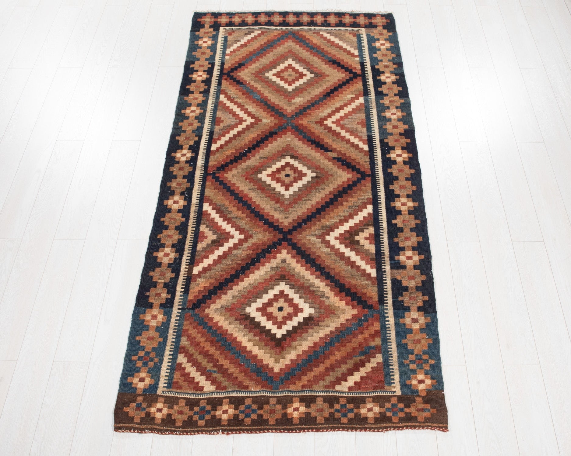 Full view of the multicolor Persian Kurdish kilim rug with a diamond zigzag flatweave pattern.