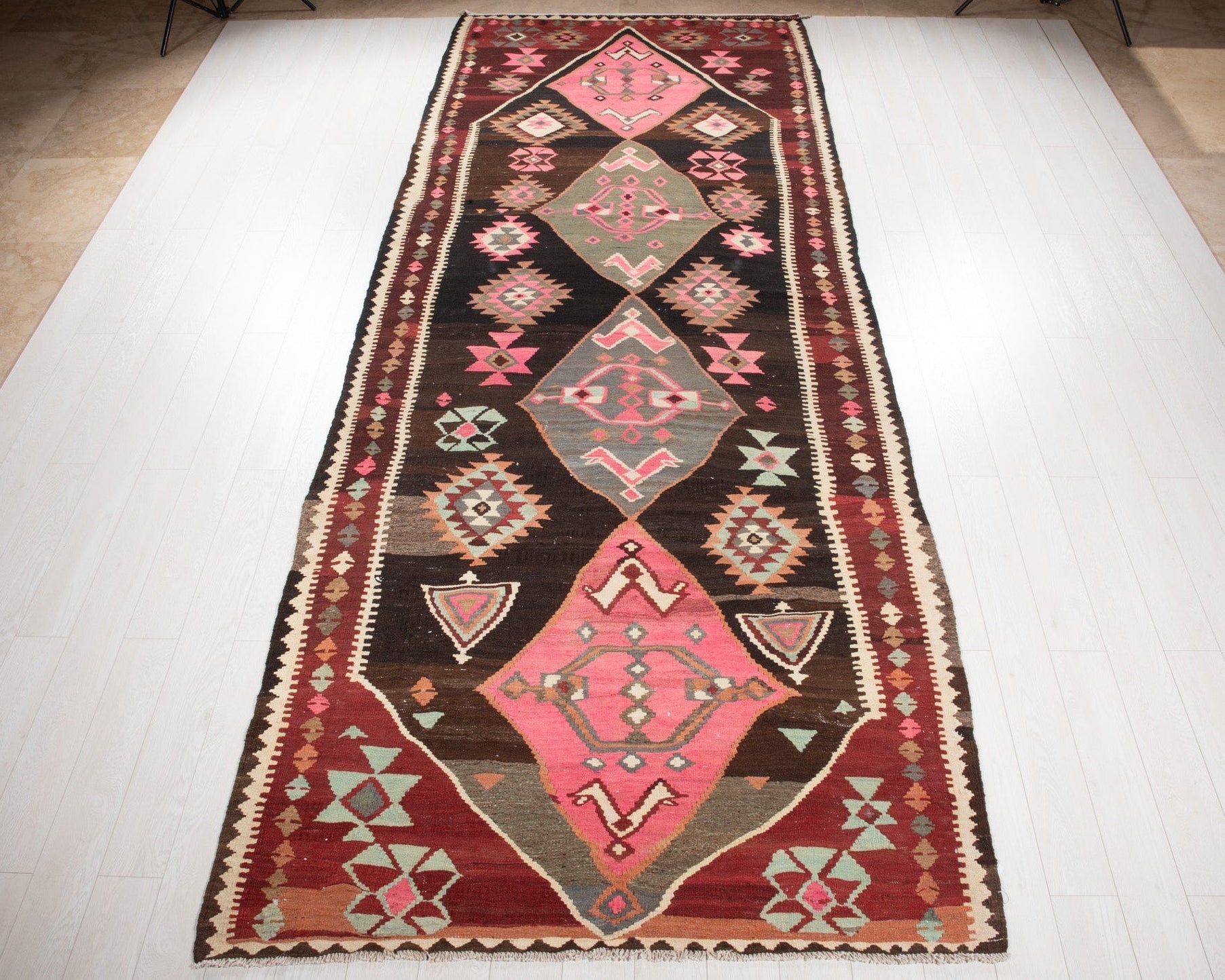 Full view of the vintage Persian Shiraz kilim runner rug in pink, black and red tribal diamond design.