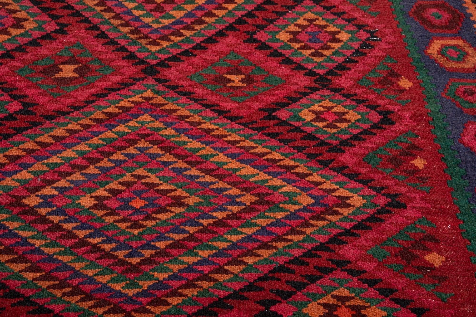 Extreme close-up of the handwoven wool kilim texture and diamond weave detail.