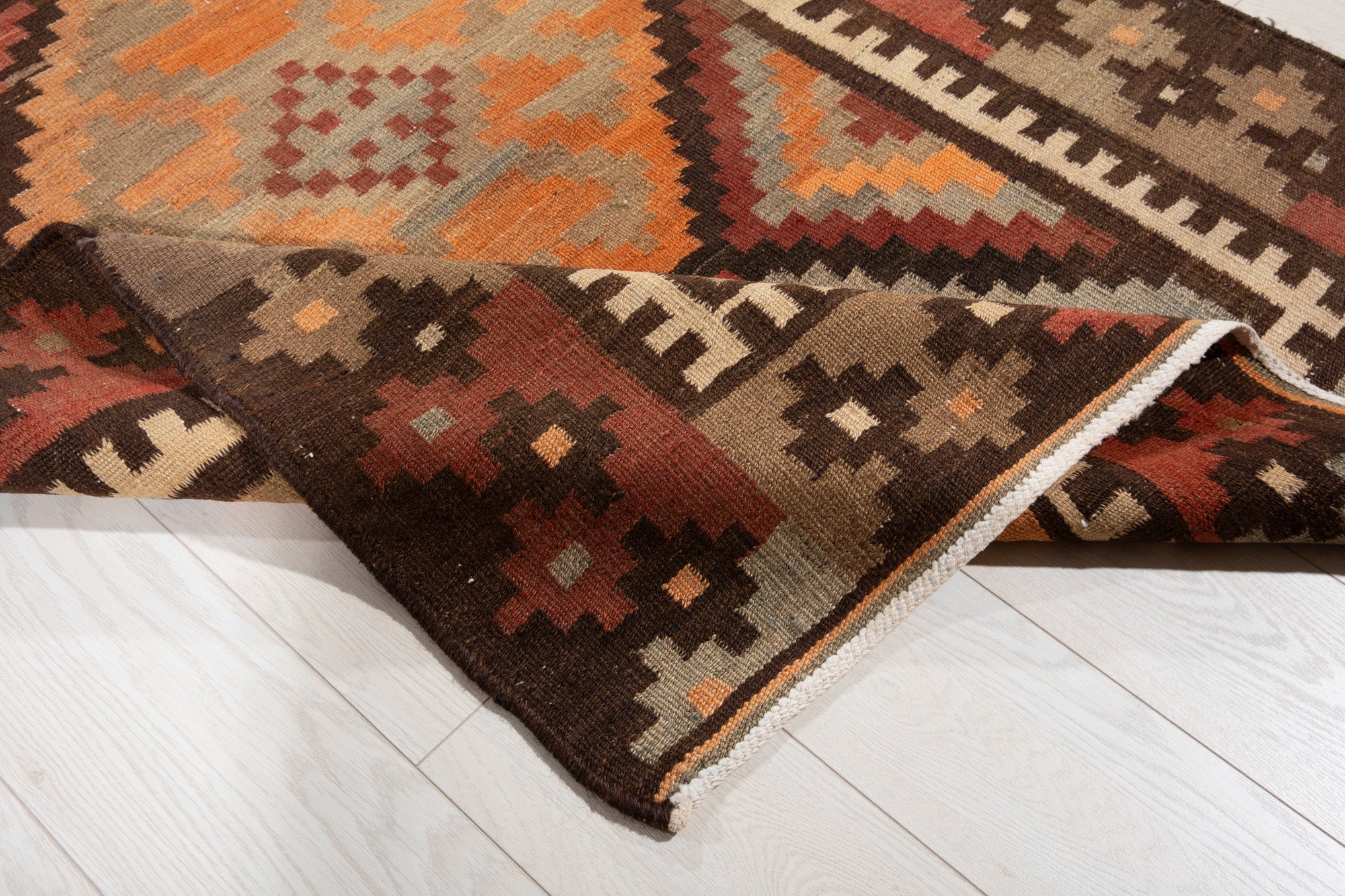 Corner of the kilim runner folded up, showing its border and edge detail.