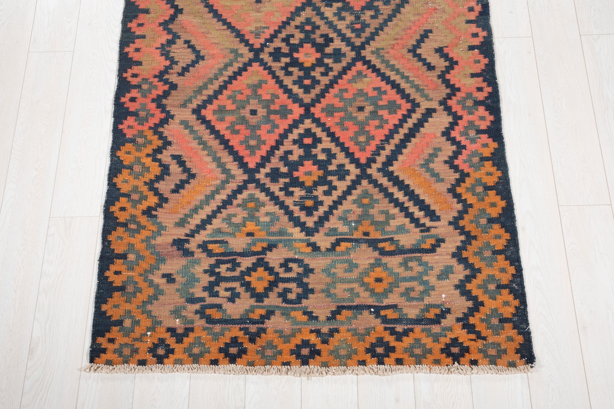 One end of the runner showing its diamond medallion and geometric border.