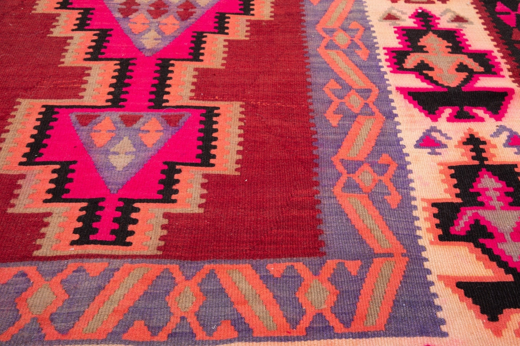 Close-up of the handwoven wool kilim's triangle and diamond motifs.