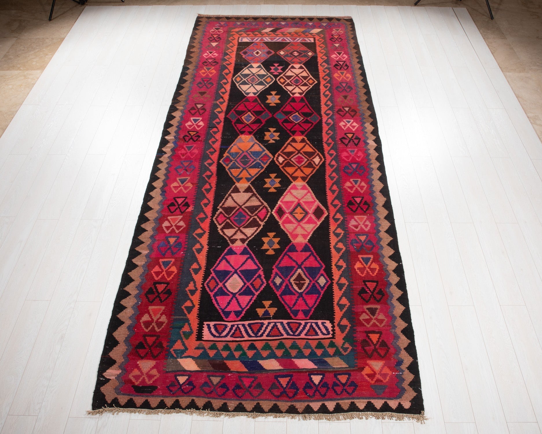 Full view of the vintage Persian Shiraz kilim rug in red and black geometric diamonds.