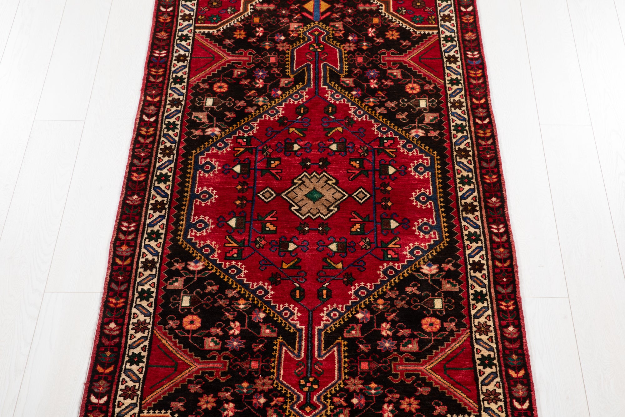 Center medallion of Hand-Knotted Vintage Wool Runner Rug – 9' 3" x 3' 5" featuring traditional motifs in red, black, and beige hues.