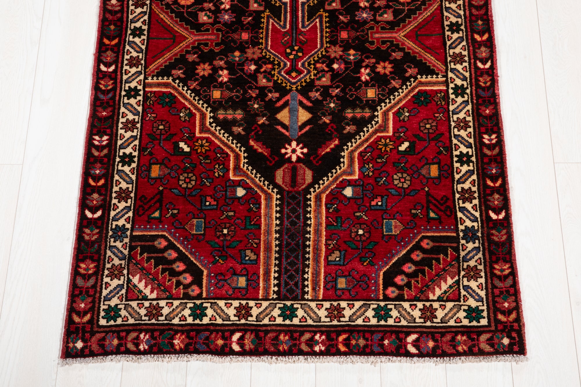 Bottom section of Hand-Knotted Vintage Wool Runner Rug – 9' 3" x 3' 5" with floral and geometric patterns in deep red and ivory.