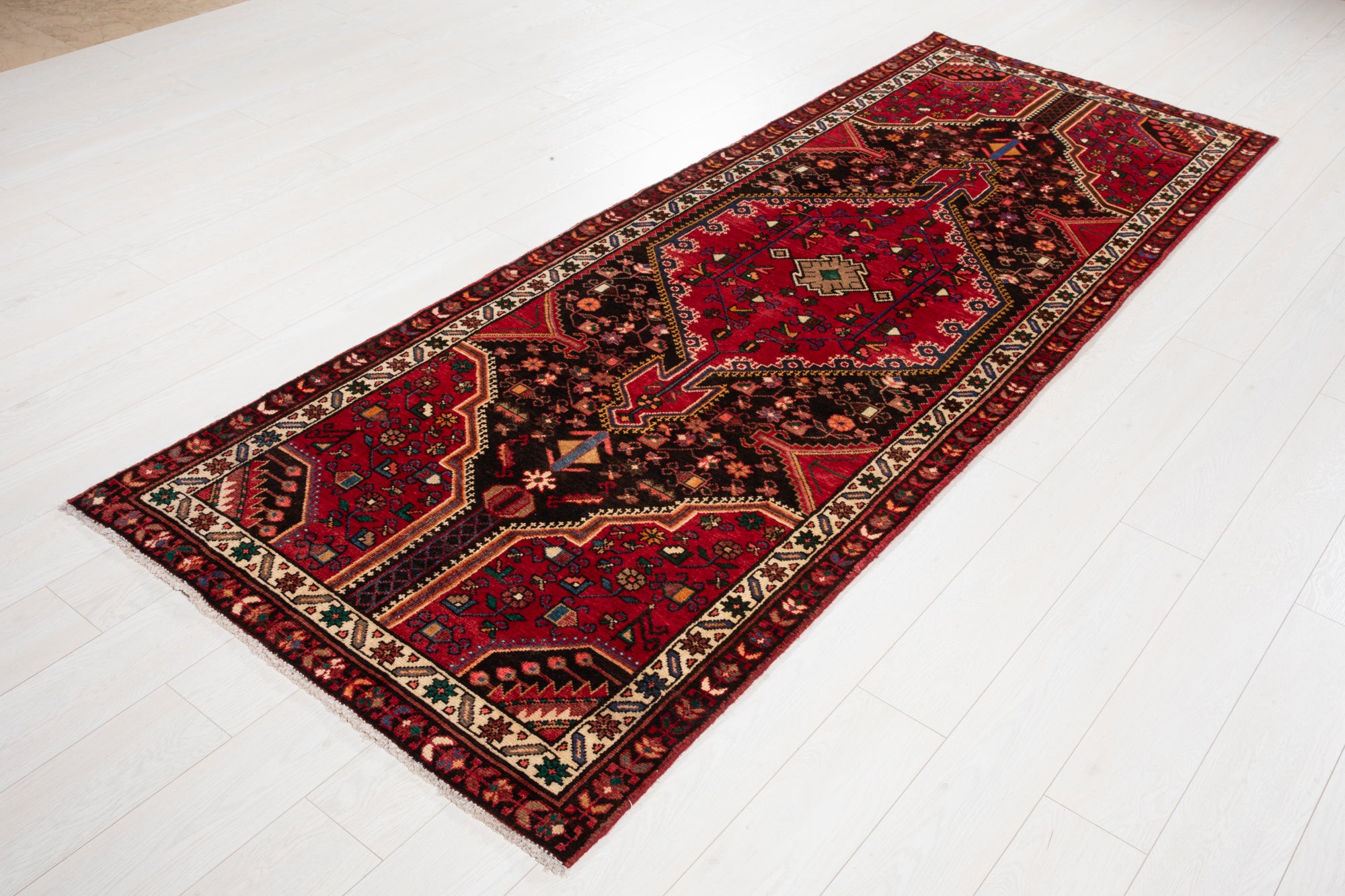 Angled view of Hand-Knotted Vintage Wool Runner Rug – 9' 3" x 3' 5" displaying its elongated shape and symmetrical tribal design.