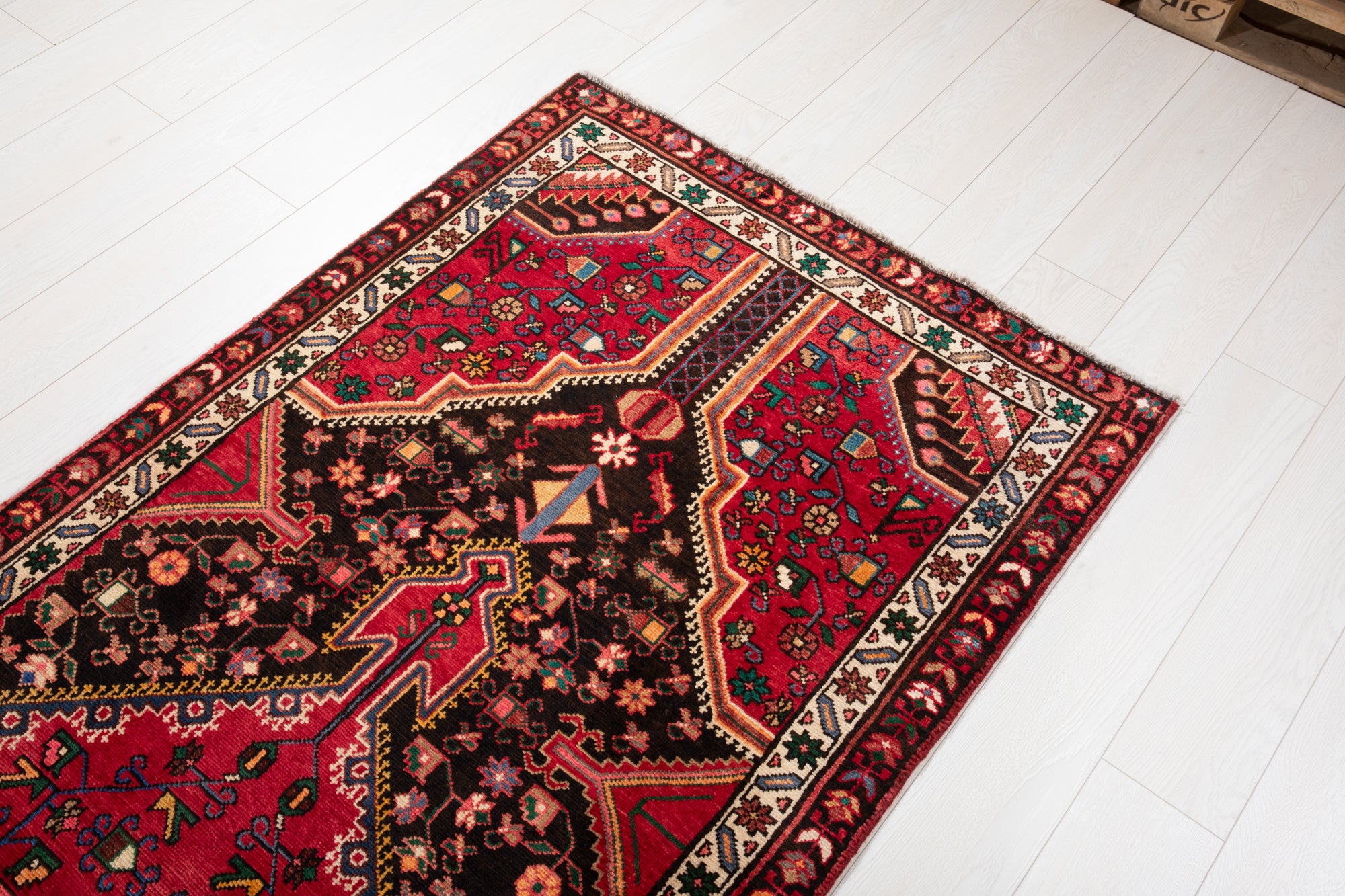 Corner detail of Hand-Knotted Vintage Wool Runner Rug – 9' 3" x 3' 5" with intricate red, green, and ivory floral motifs and border.