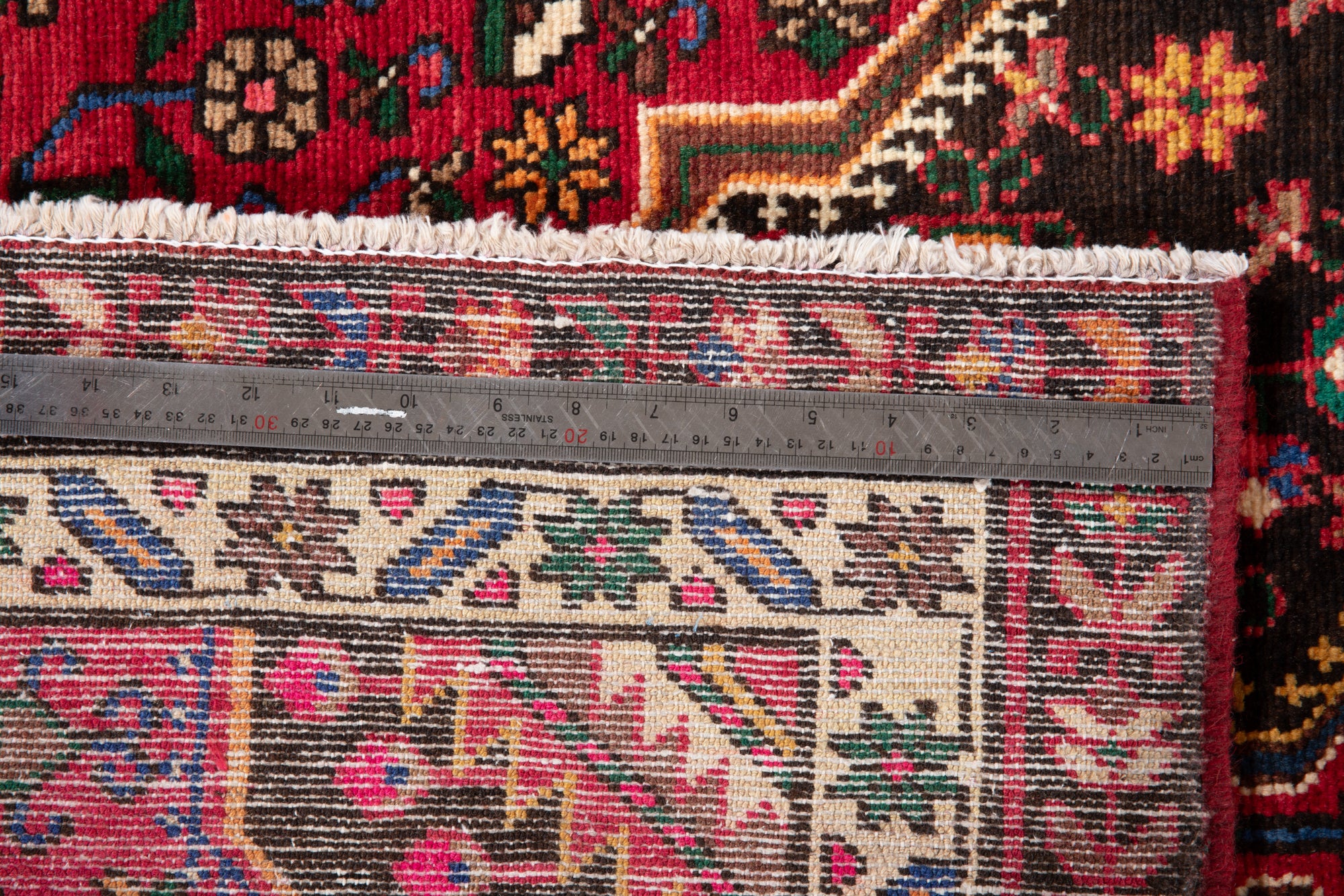 Close-up of ruler on back of Hand-Knotted Vintage Wool Runner Rug – 9' 3" x 3' 5" demonstrating knot density and craftsmanship.