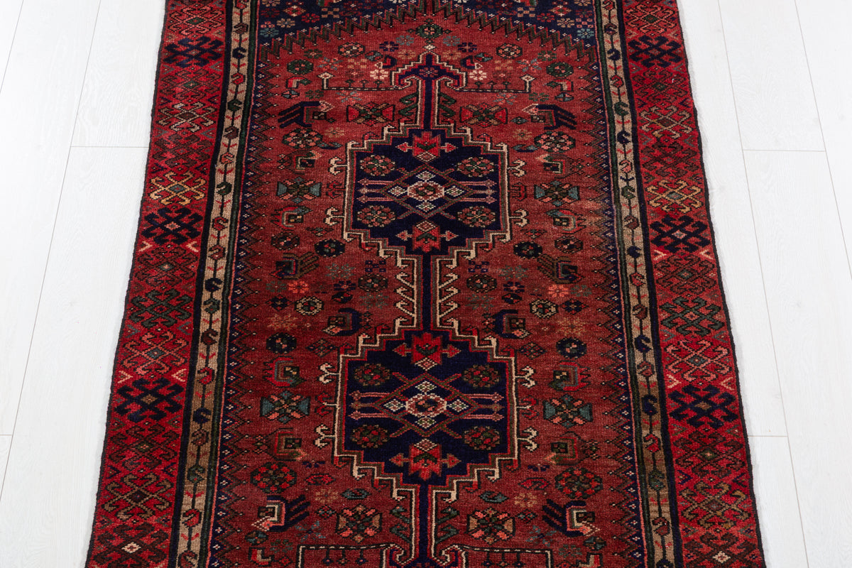 Tapis vintage rouge rouille et bleu marine profond à médaillon géométrique allongé – 6' 5" x 3' 2" (195 x 96 cm)