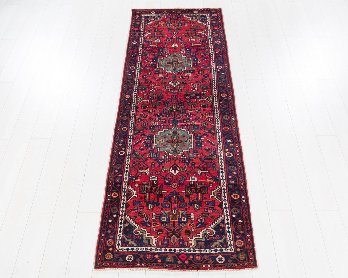 Vintage Hamadan narrow floral medallion wool runner rug in pinkish red and navy blue, SKU 5234