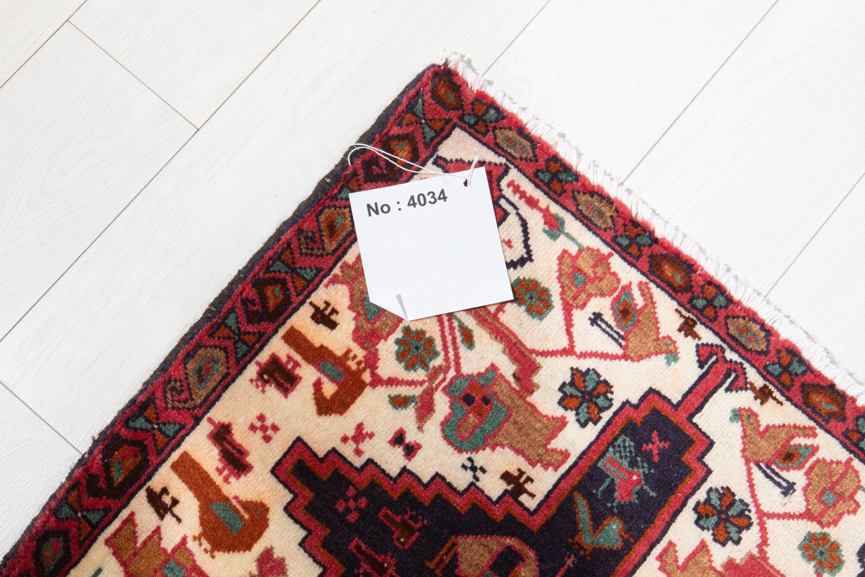 Corner of the rug with an attached inventory tag showing its rug number.