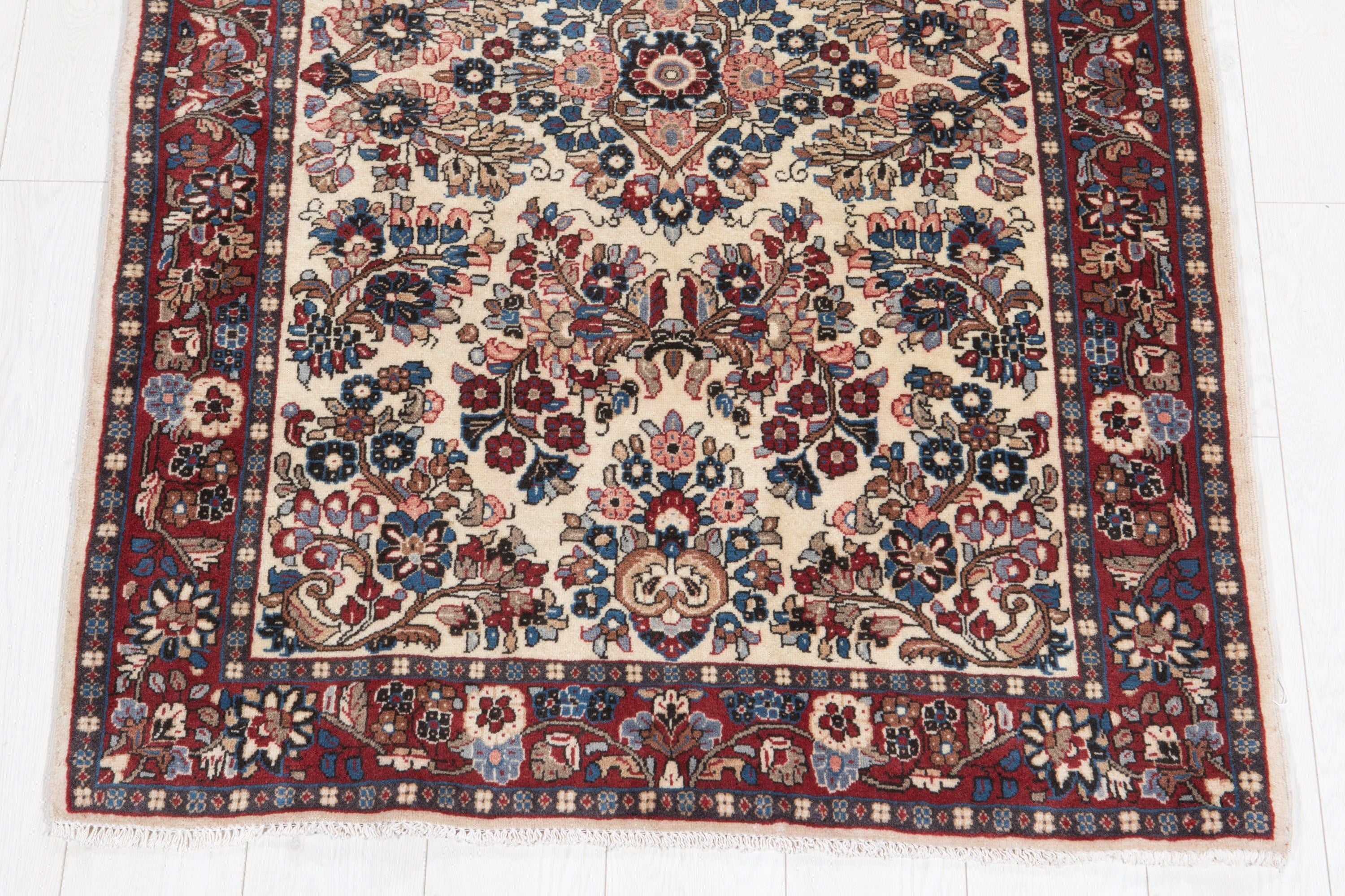 Straight-on full view of the rug showing the floral pattern, border, and bottom fringe.