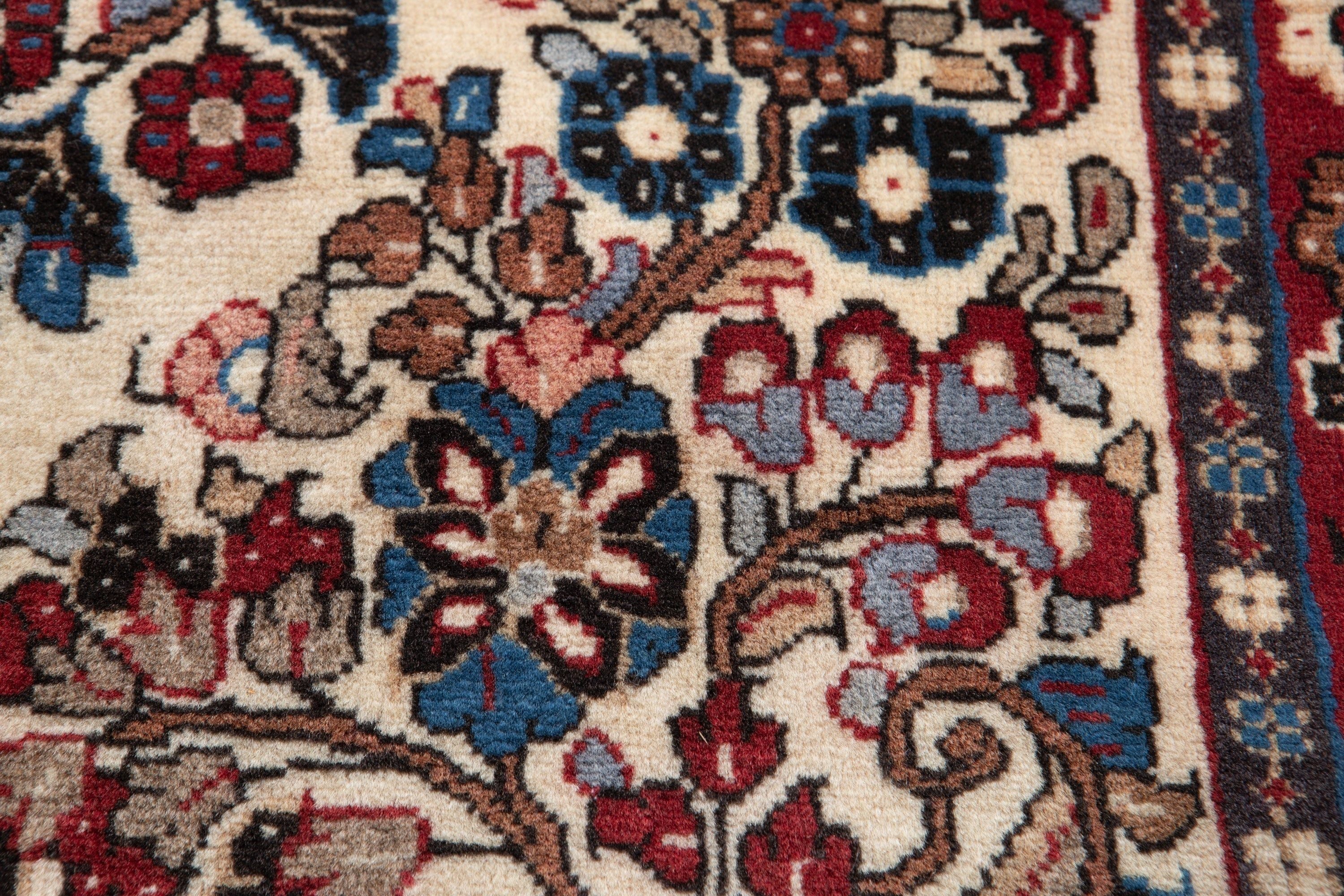 Extreme close-up of the floral motifs, showing fine wool pile detail and rich color tones.
