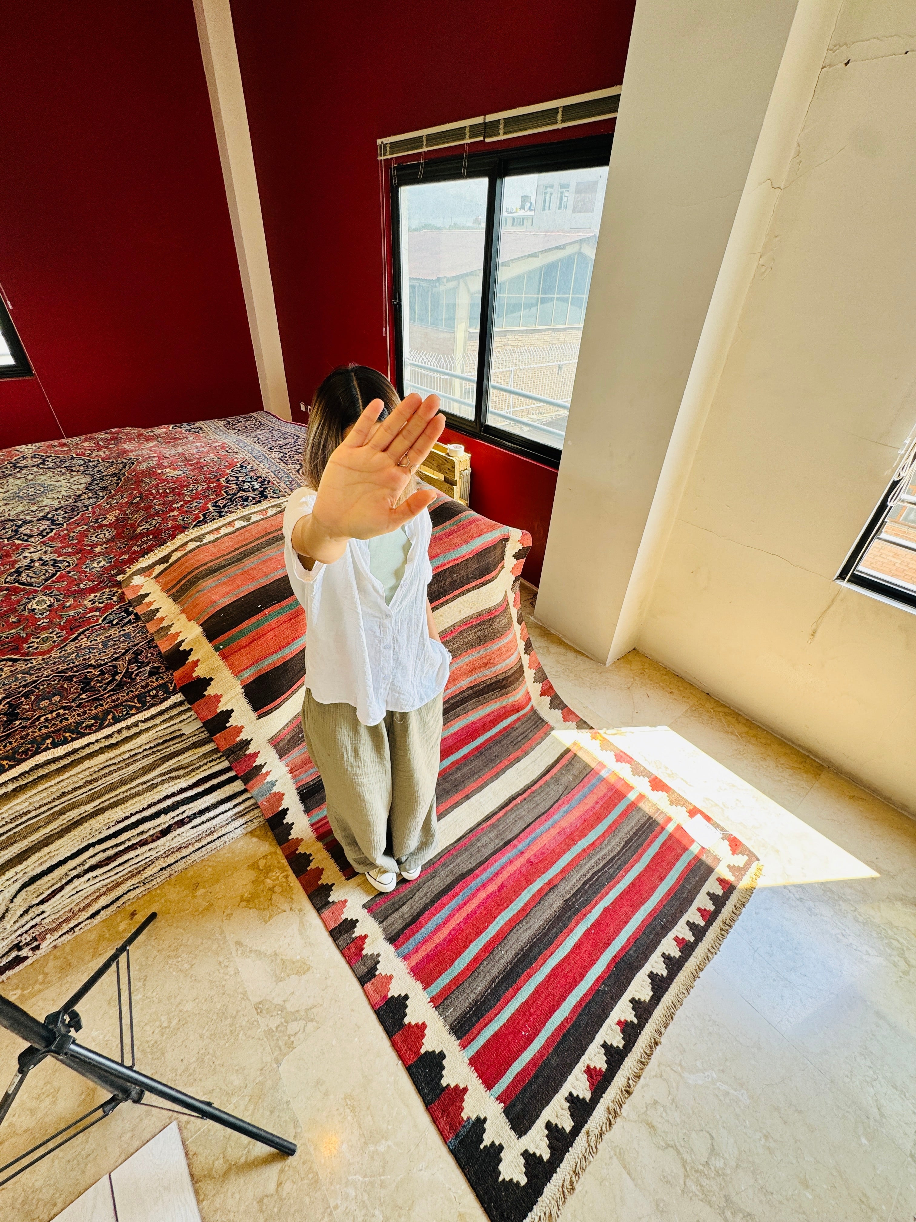 Studio photo shoot of the striped kilim runner with a woman standing on it.