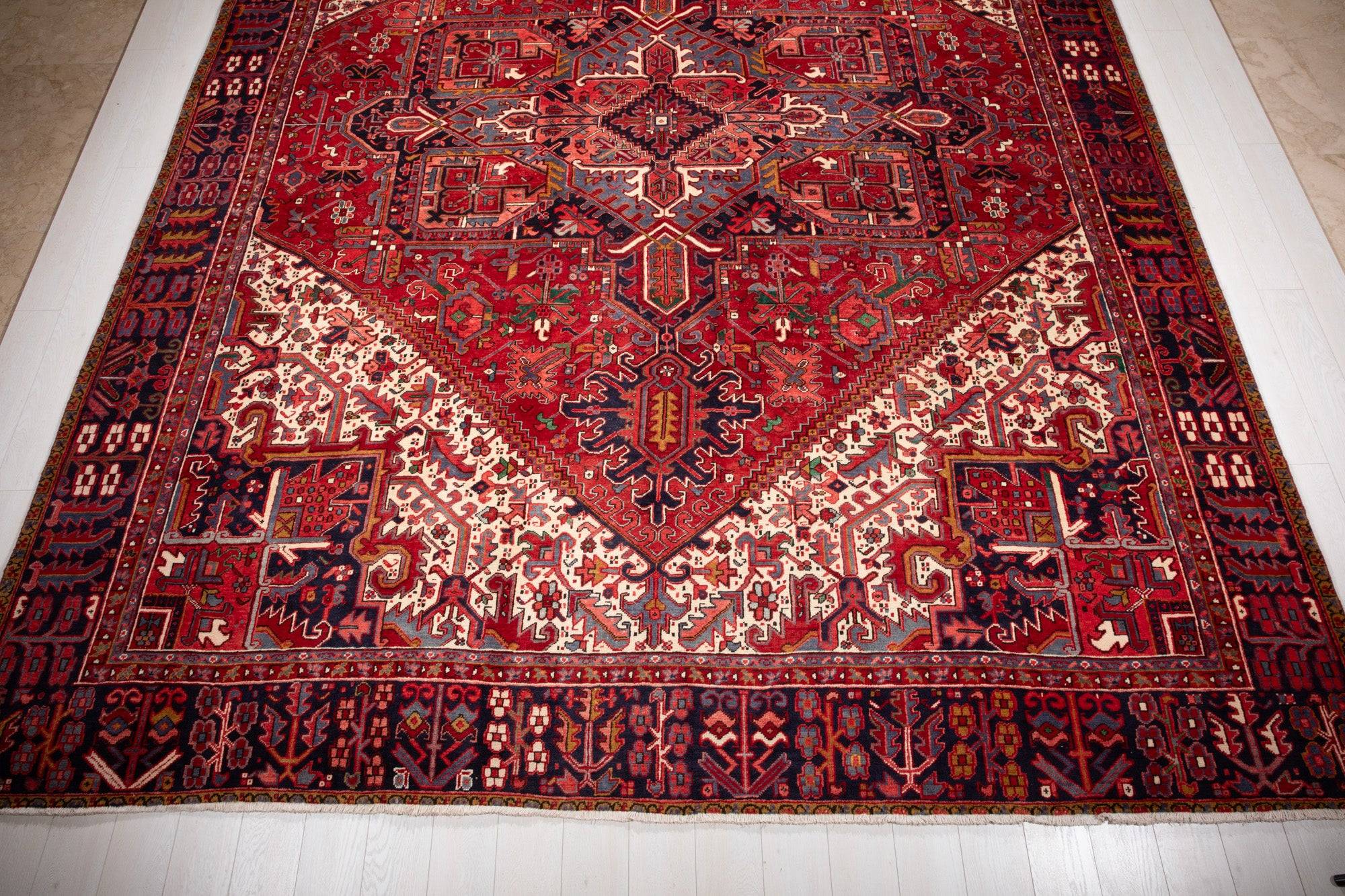 Floor-level view of one end of the rug showing the cream field and medallion point.