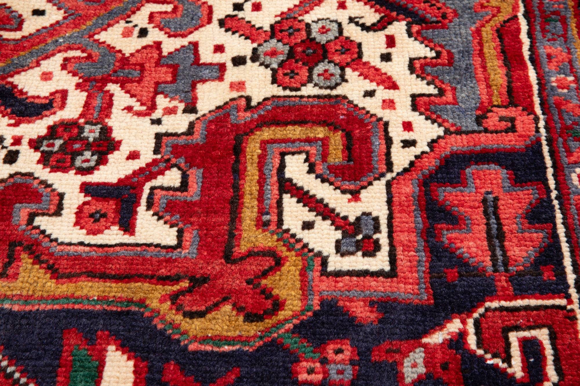Extreme close-up of the medallion edge showing wool pile texture and floral motifs.