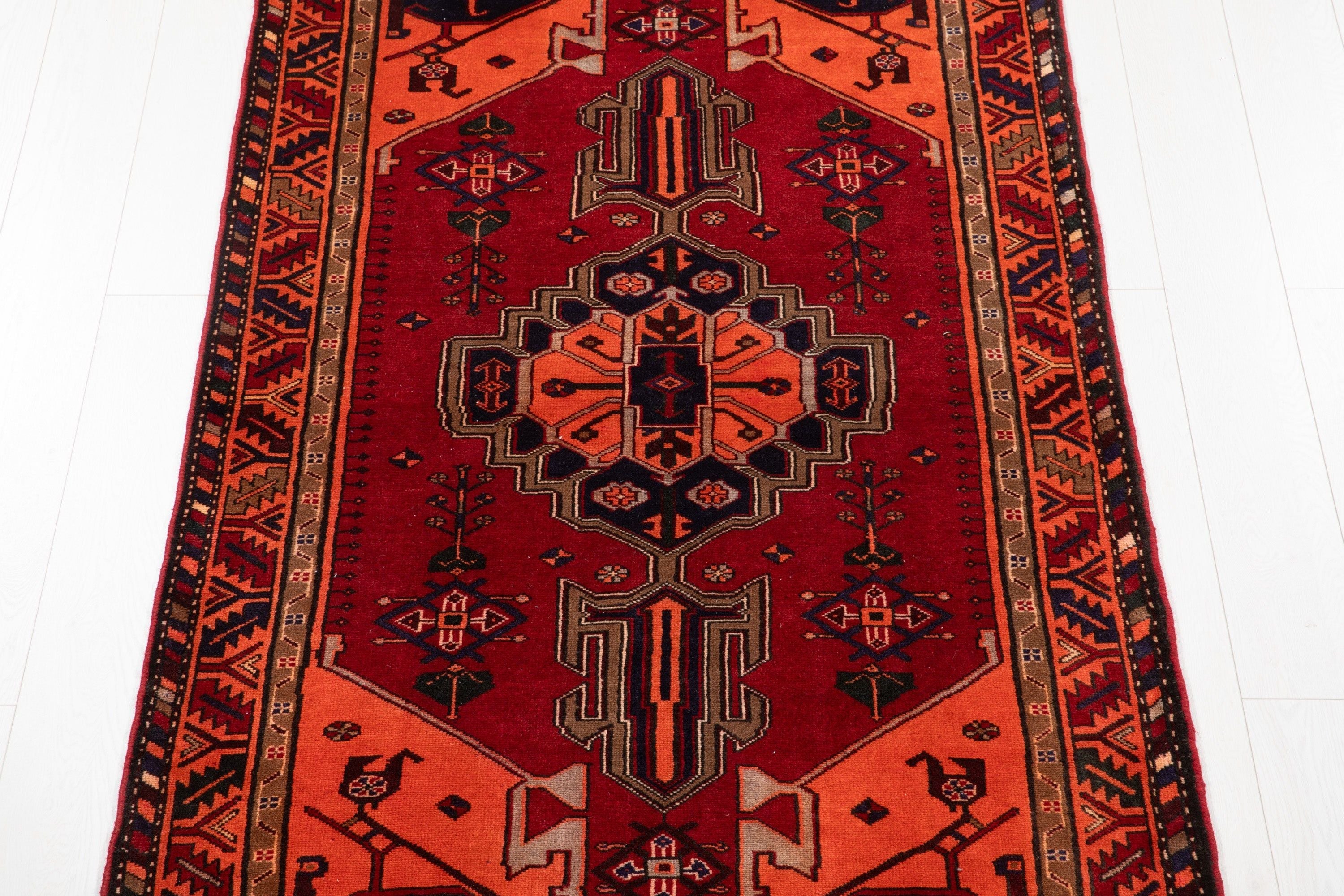 Top-down view of the rug showing the stepped medallion pattern in red and orange.
