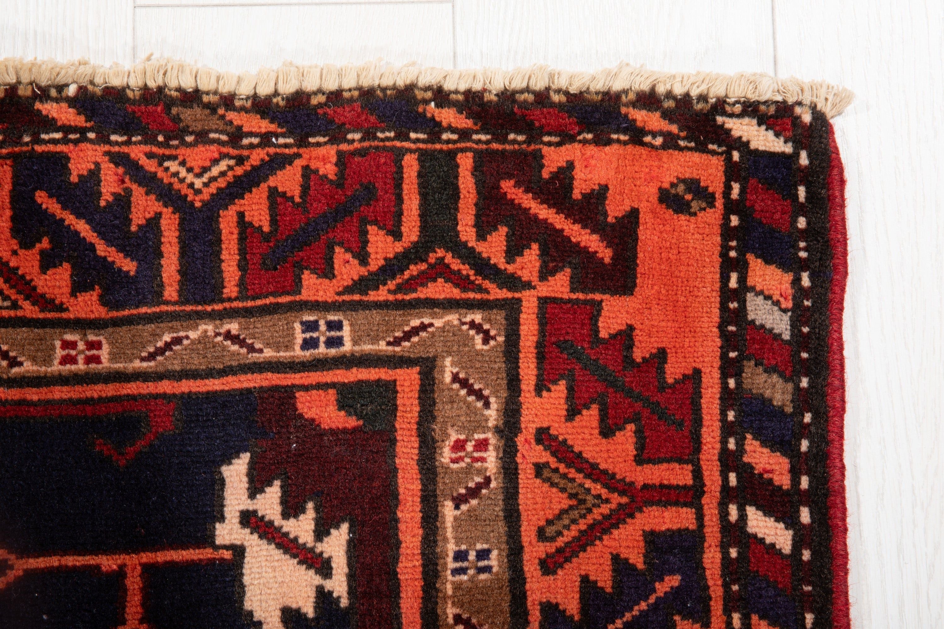 Corner close-up showing the zigzag border pattern and fringe edge in detail.