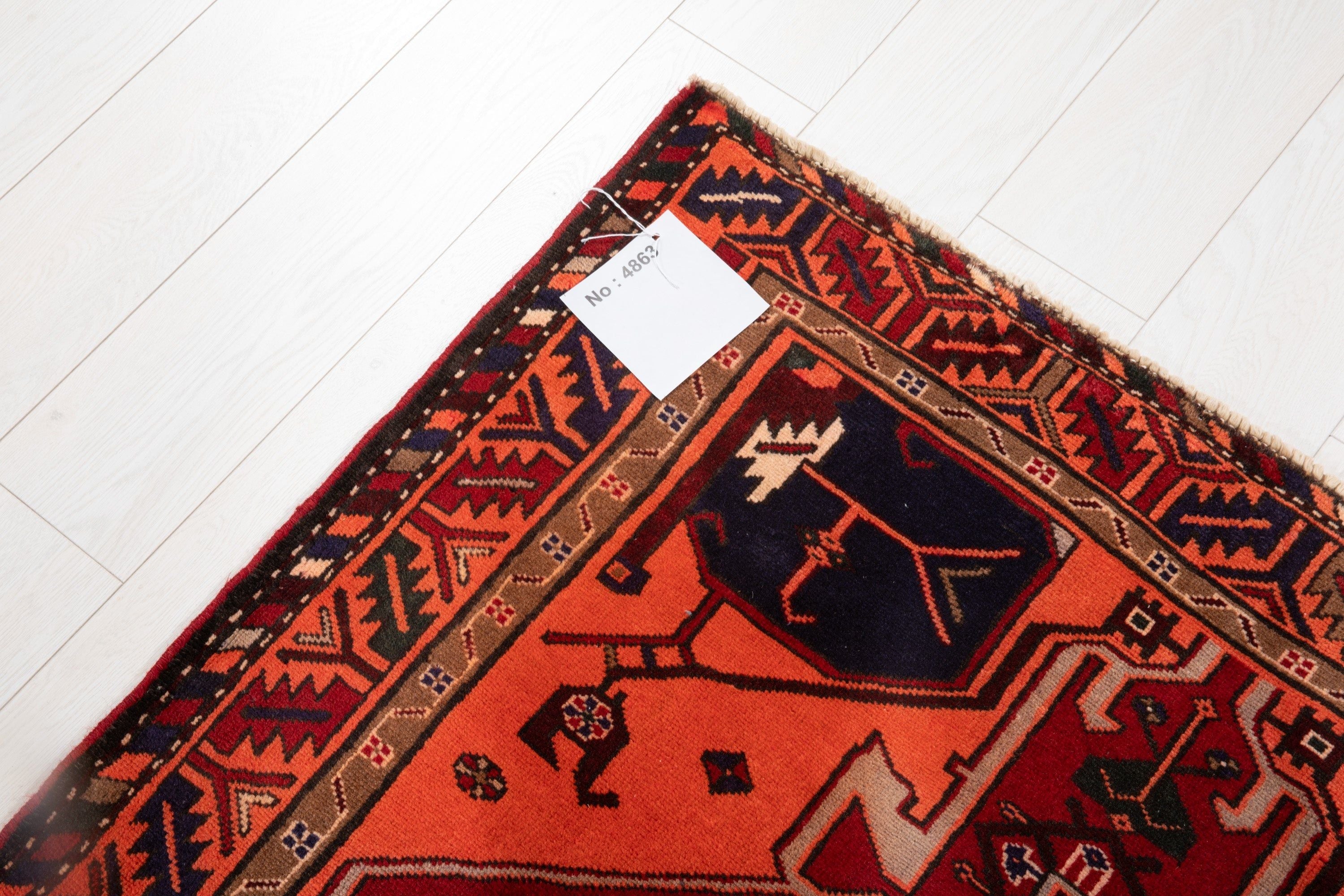 Corner of the rug with an attached inventory tag showing its rug number.