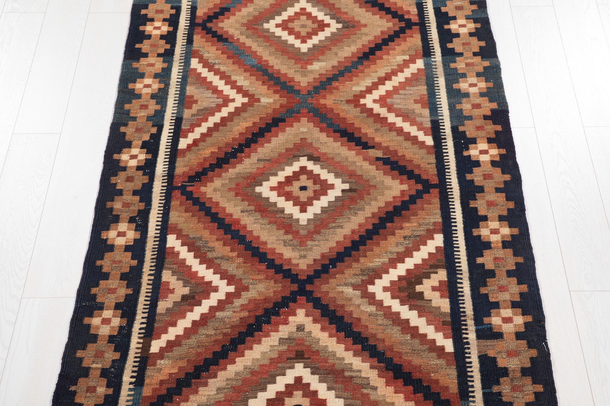 Top-down view of the kilim rug showing the repeating diamond pattern in full.