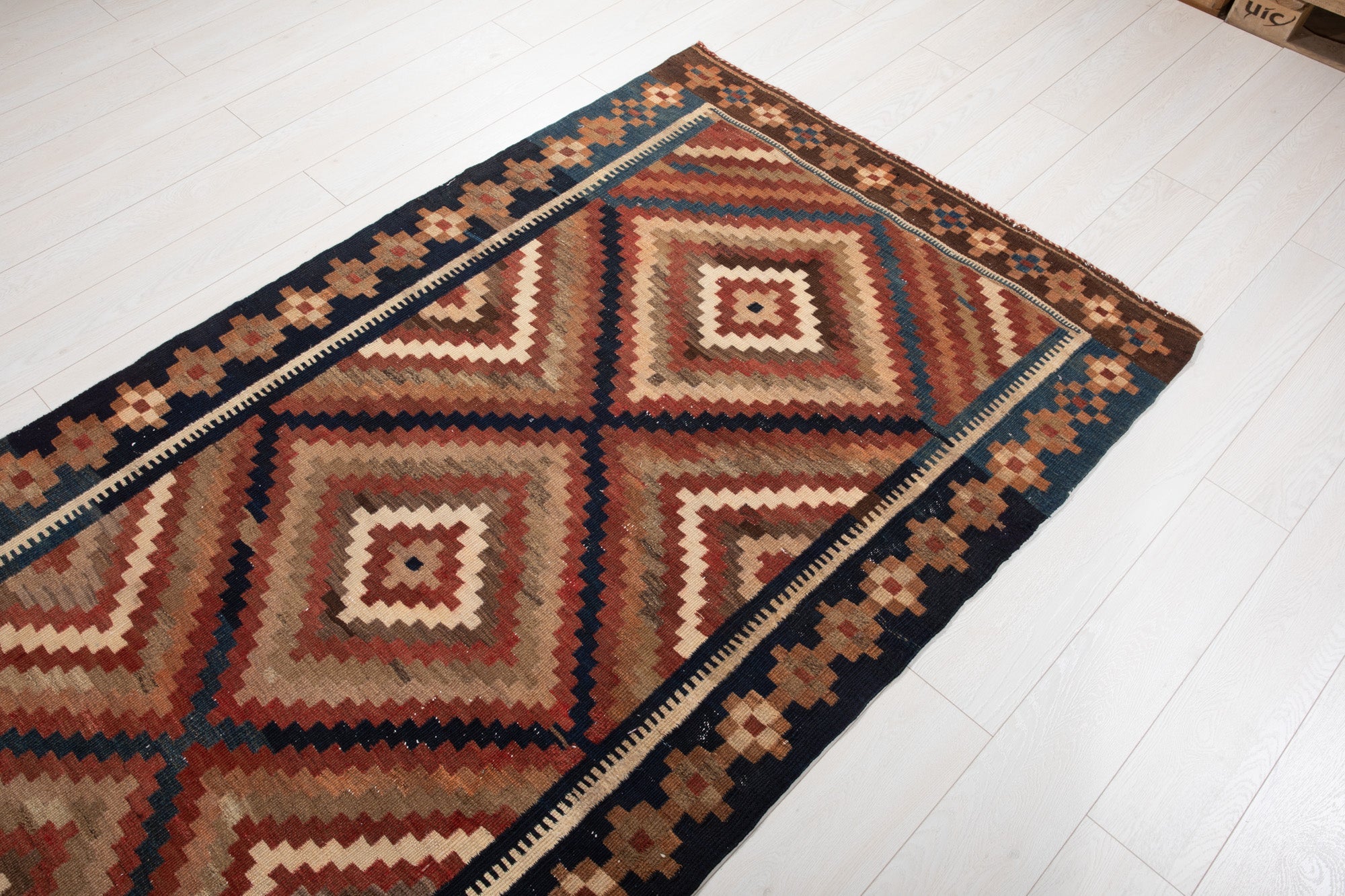 Diagonal view showing two diamond medallions of the kilim across its width.