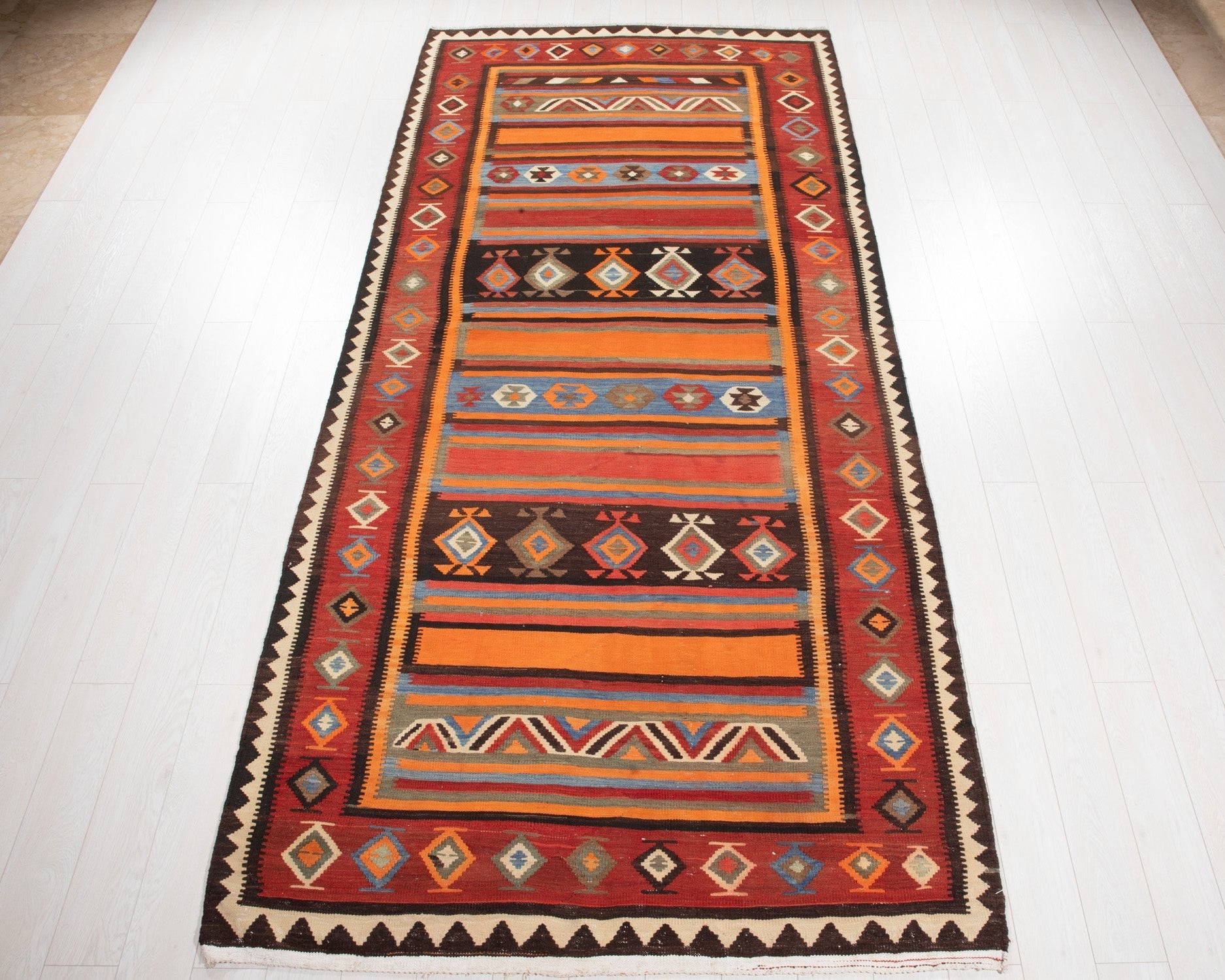 Full view of the vintage Persian Shiraz kilim runner with its multicolor striped tribal bands.