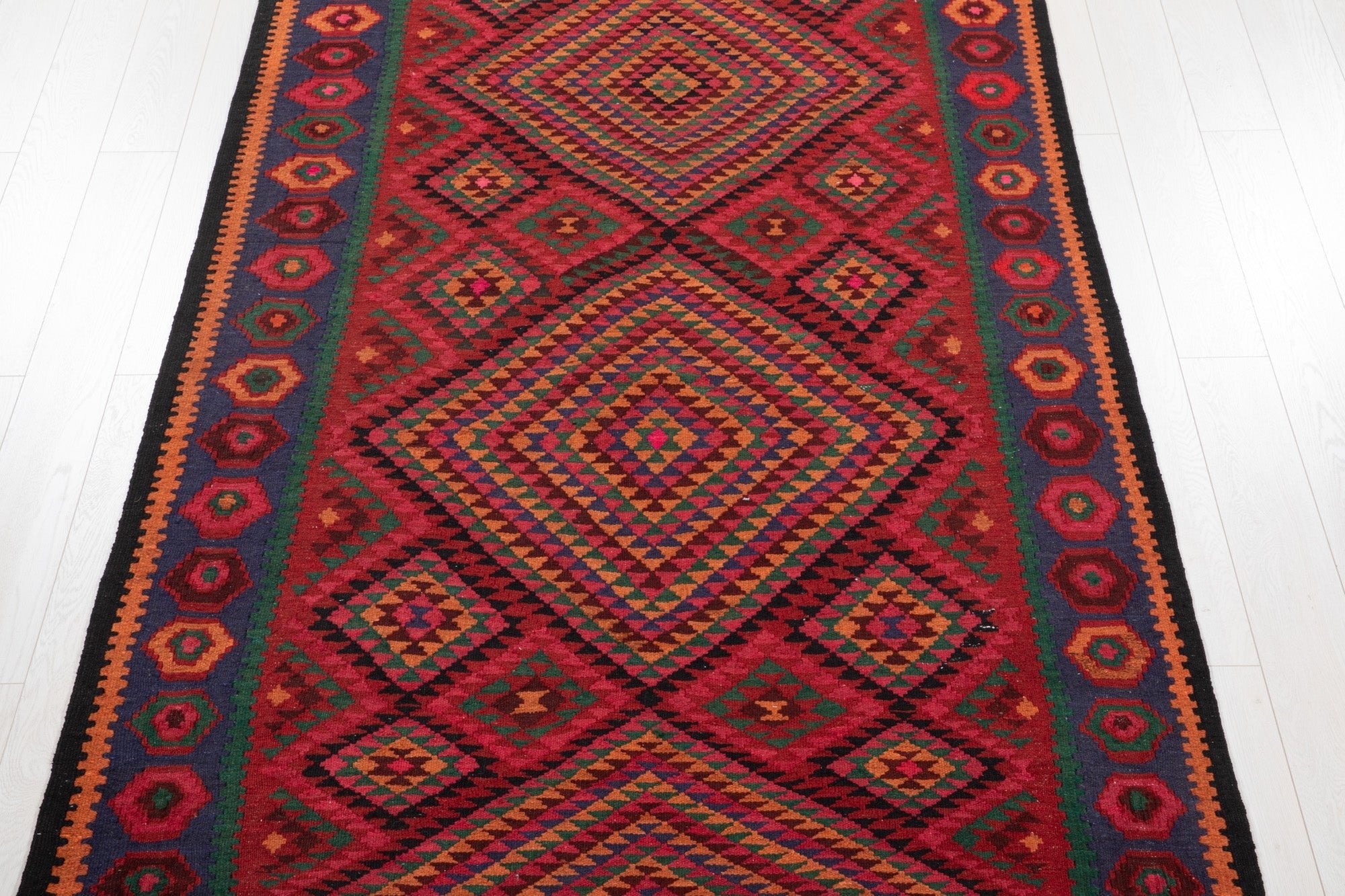Top-down view of the kilim's concentric diamond medallions and hexagon border.