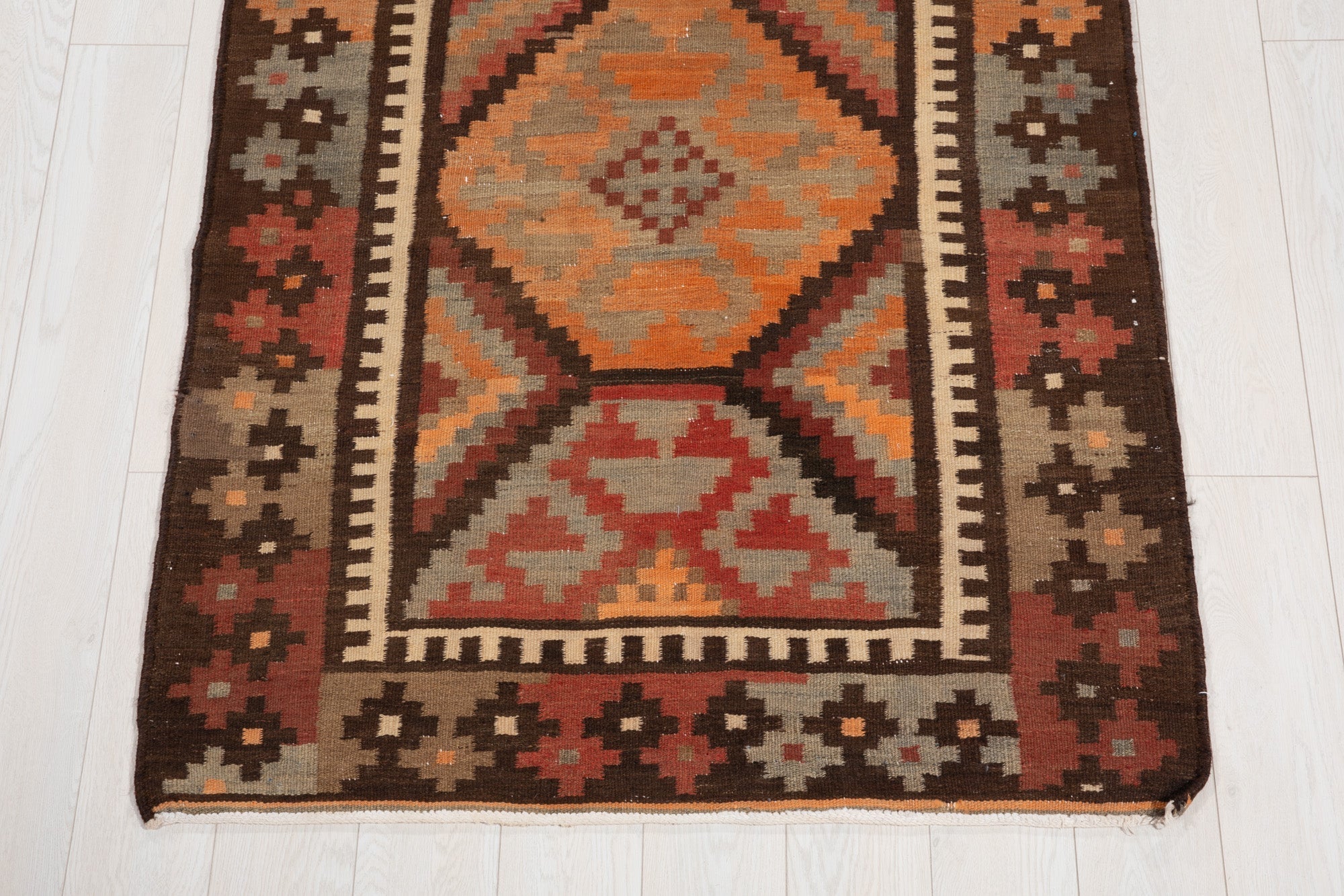 One end of the kilim runner showing its diamond medallion and geometric border.