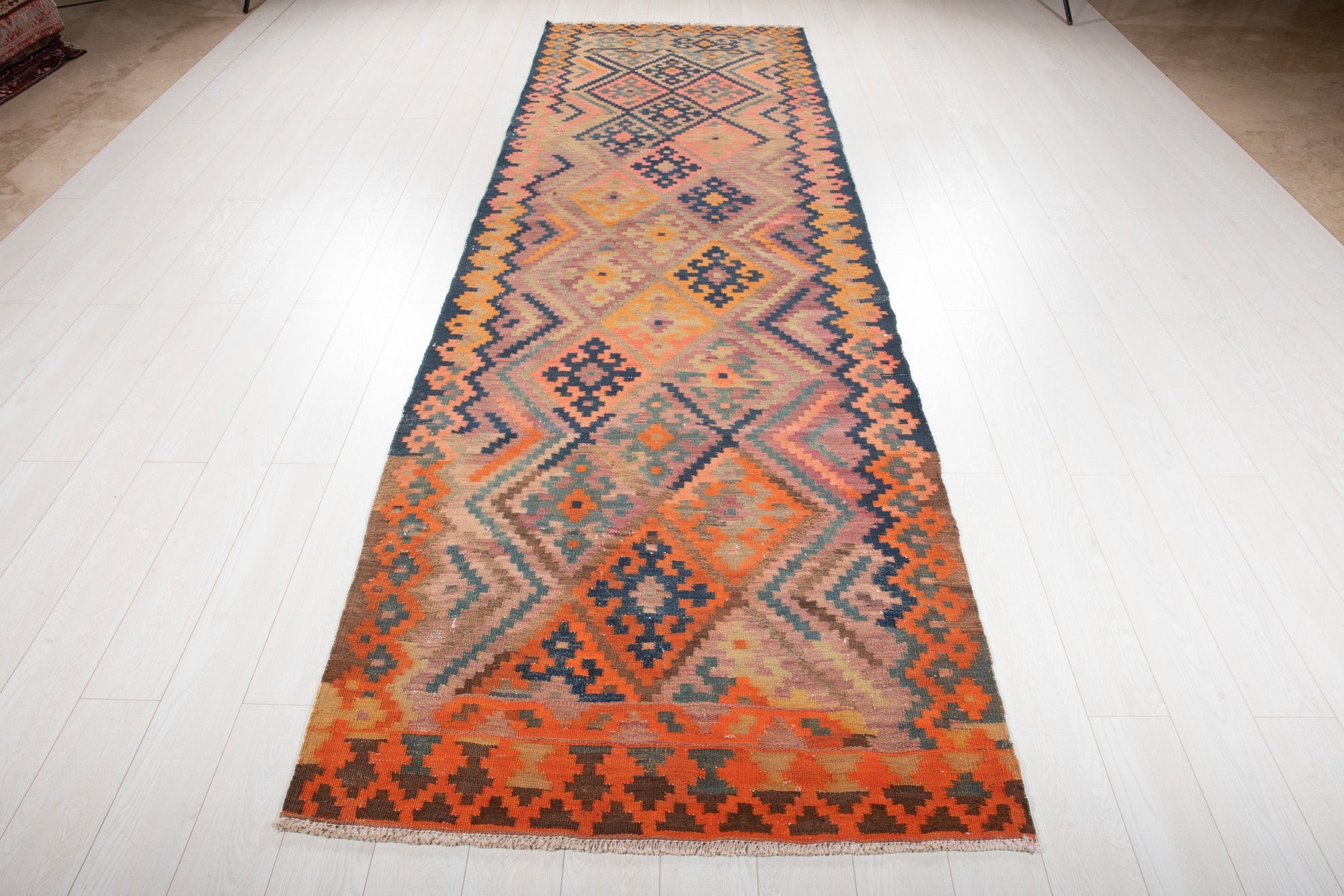 Full-length view of the runner from the opposite end, showing its bright orange border.