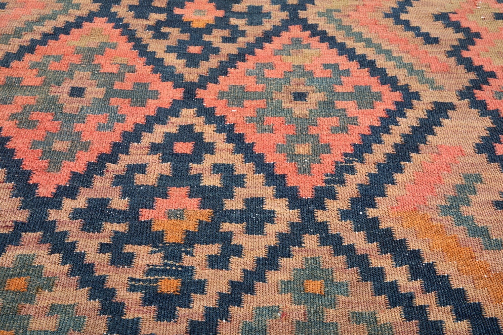 Close-up of the handwoven wool runner's diamond weave and pink cross motifs.