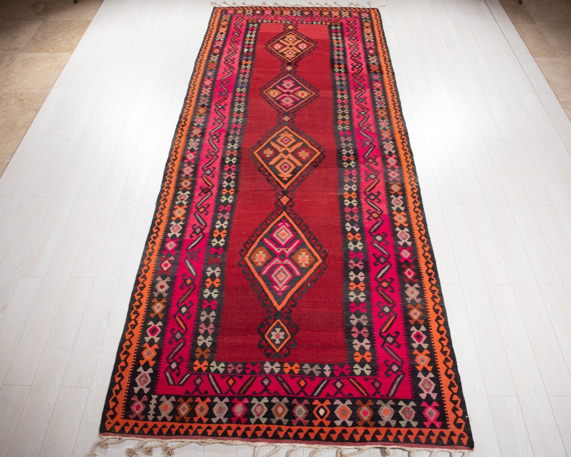 Full view of the vintage Persian Shiraz kilim runner in red and pink diamond medallions.