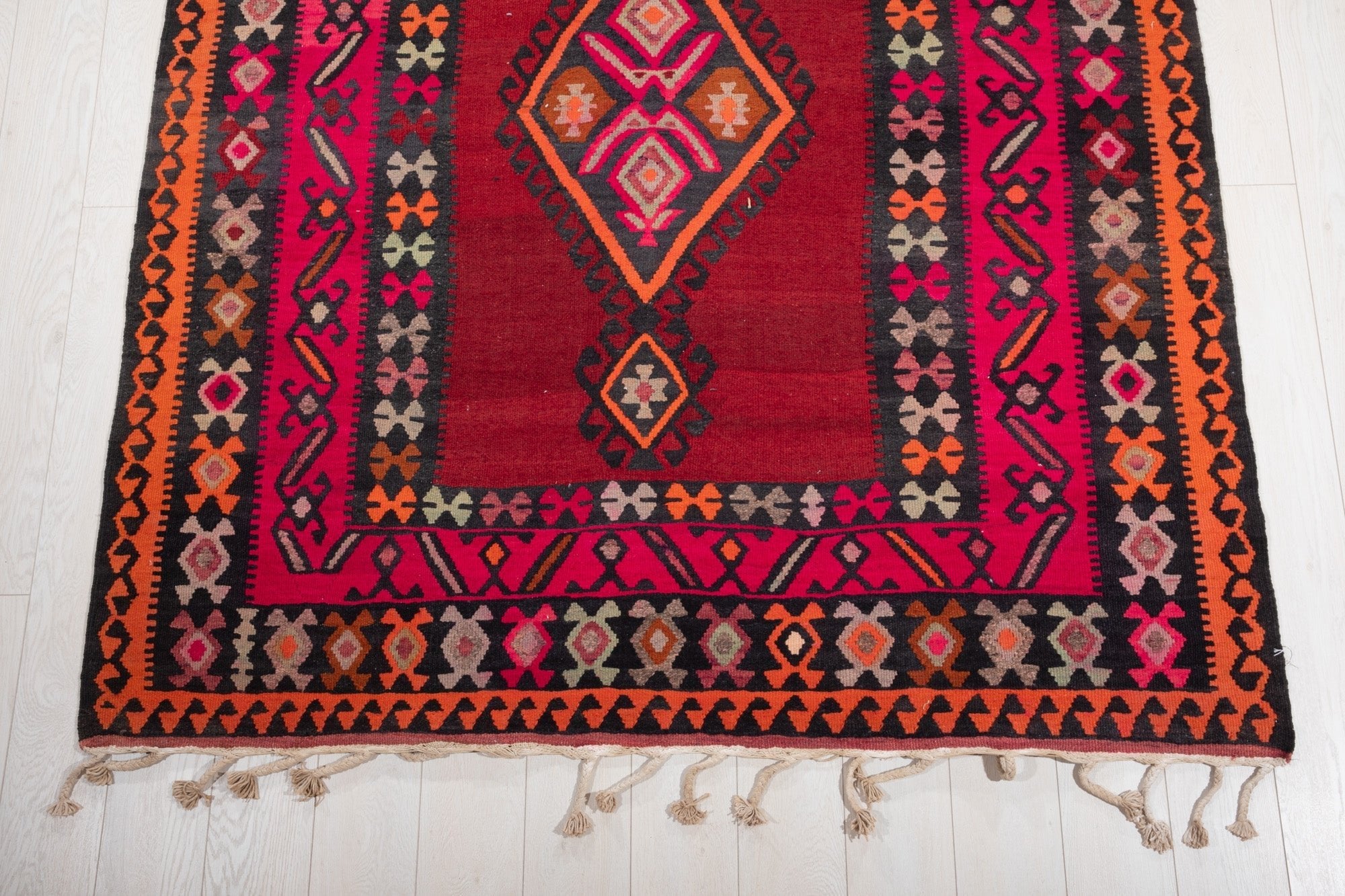 One end of the rug showing its diamond medallion and fringed edge.