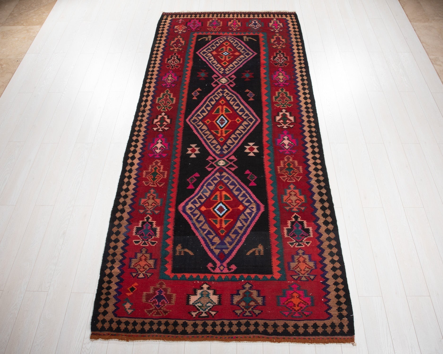 Full view of the vintage Shiraz Persian kilim rug in red and navy geometric diamonds.
