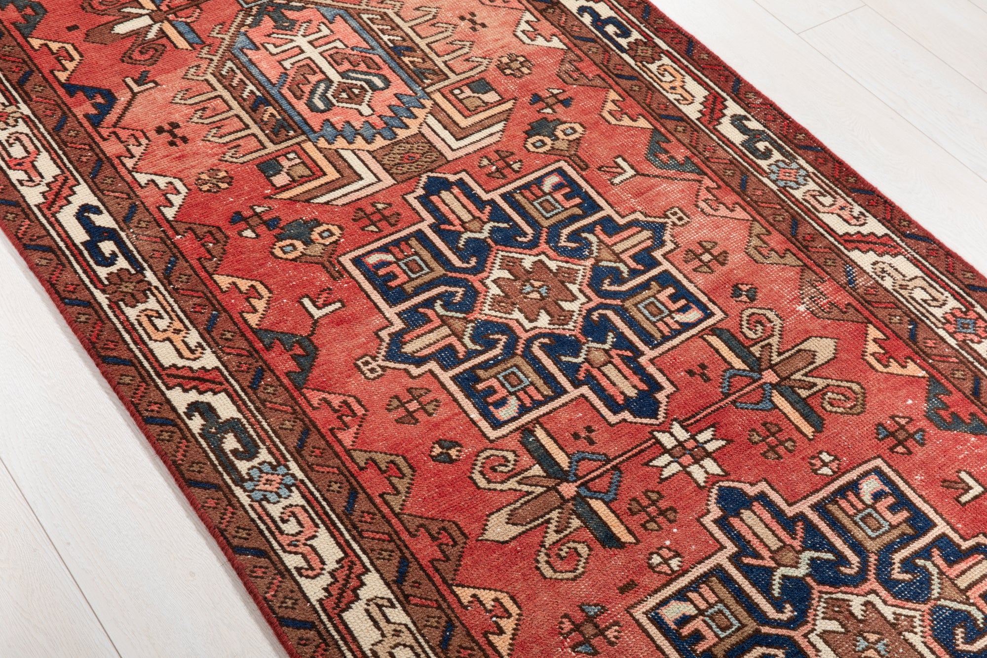 Detailed side view of Hand-Knotted Antique Wool Runner Rug – 14' 9" x 3' 4" highlighting intricate handwoven textures and vibrant red hues.