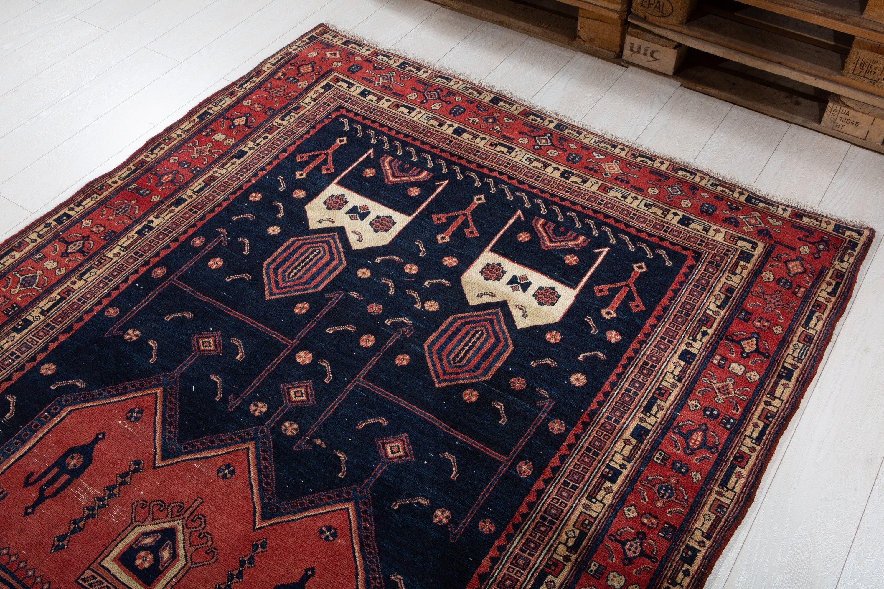 Opposite end of the rug in a warehouse setting, showing medallions and a distinct corner motif.