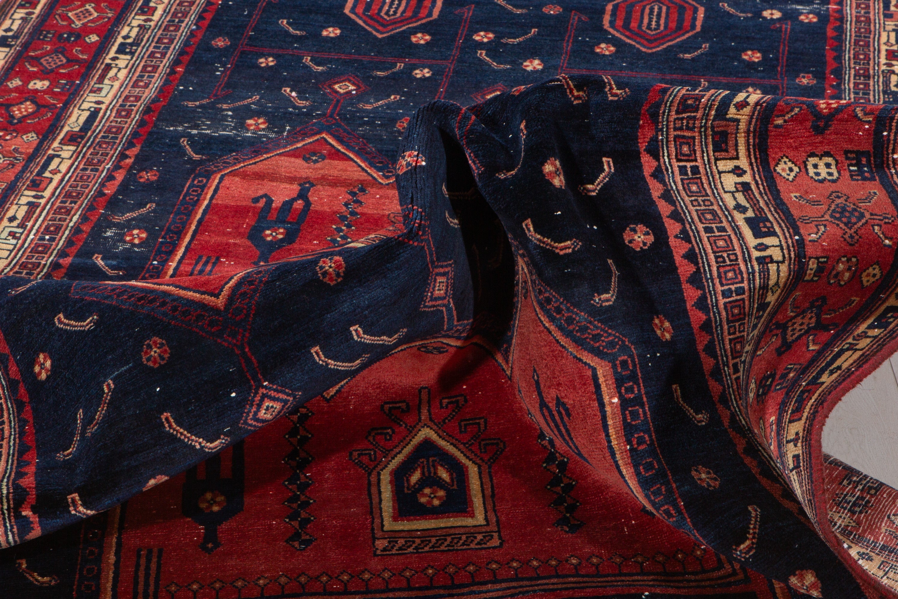 Close-up of the rug folded over itself, showing the wool pile texture and natural drape.