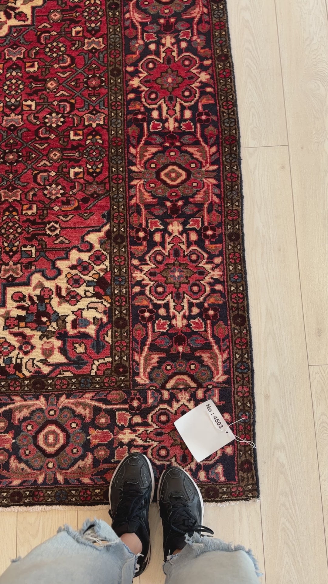 Close-up of Hand-Knotted Vintage Wool Area Rug 10' x 5' 5" corner showing floral border details and price tag, perfect for home and garden decor.