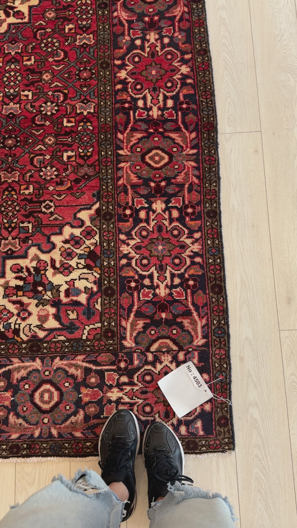 Close-up of Hand-Knotted Vintage Wool Area Rug 10' x 5' 5" corner showing floral border details and price tag, perfect for home and garden decor.