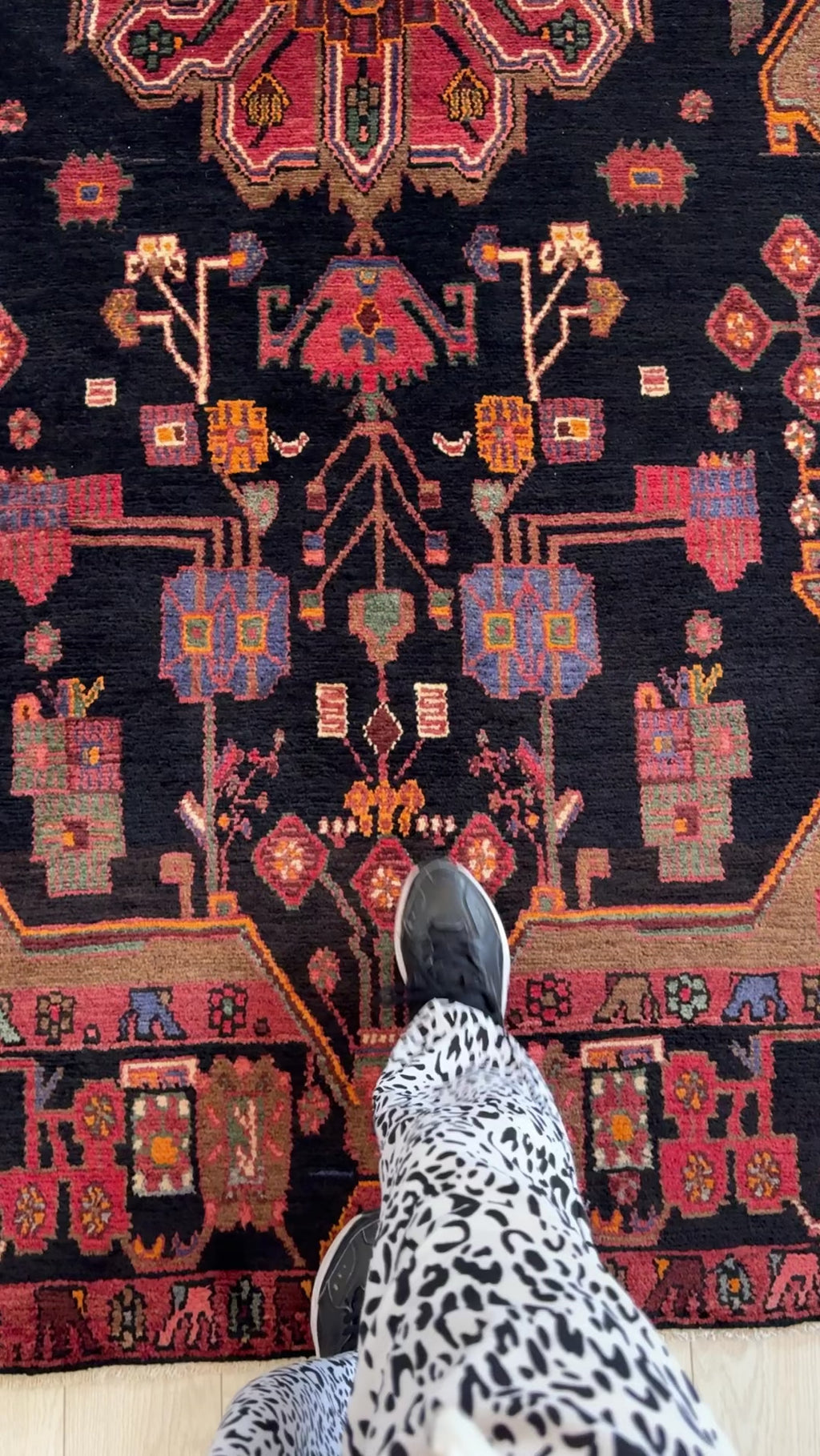 Close-up of Hand-Knotted Vintage Wool Area Rug – 9' 2" x 4' 11" highlighting the colorful floral and geometric designs with a foot for scale.