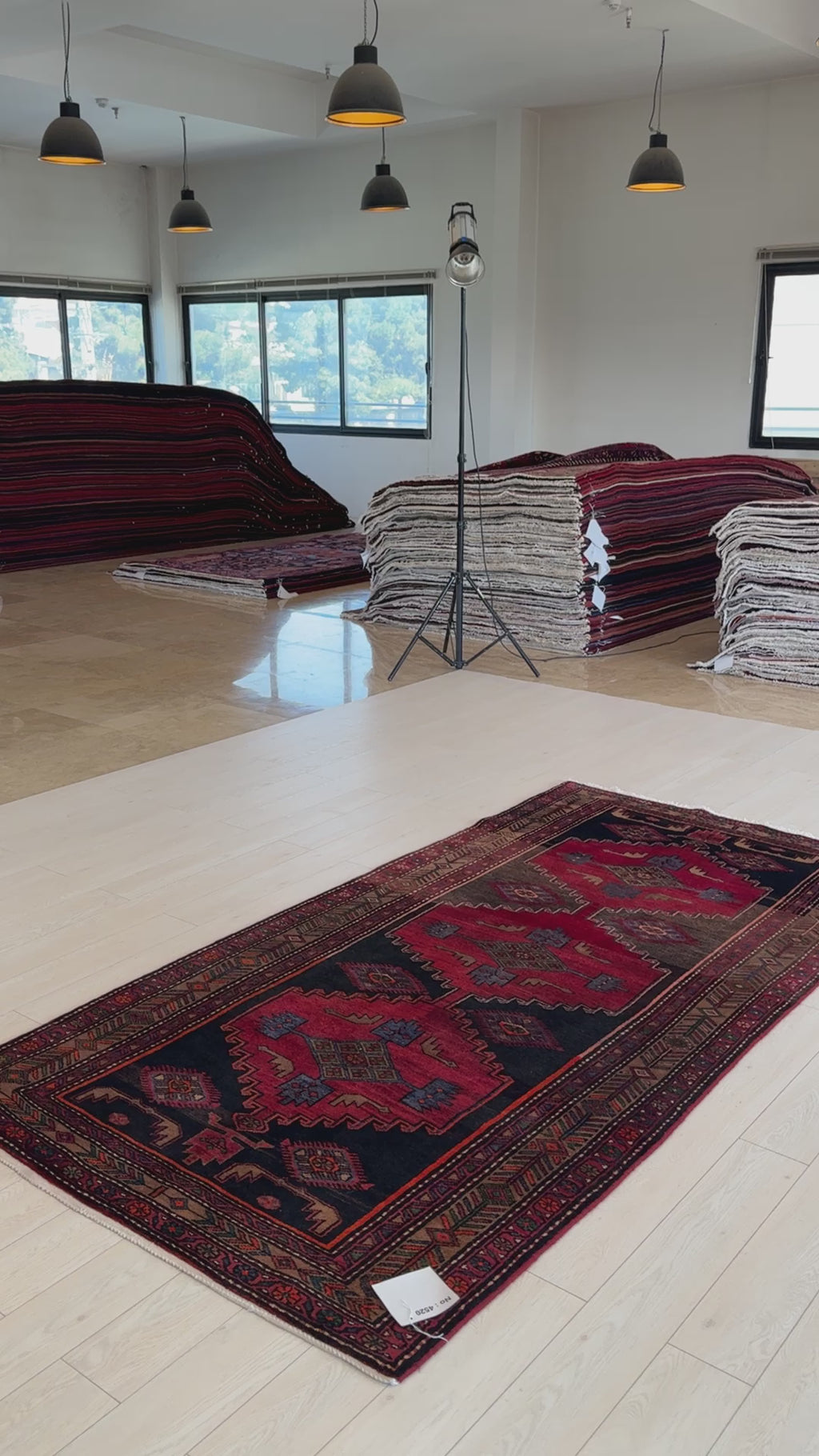 Hand-knotted vintage wool rug laid out in a showroom with natural light, highlighting its bold tribal design and artisan craftsmanship.