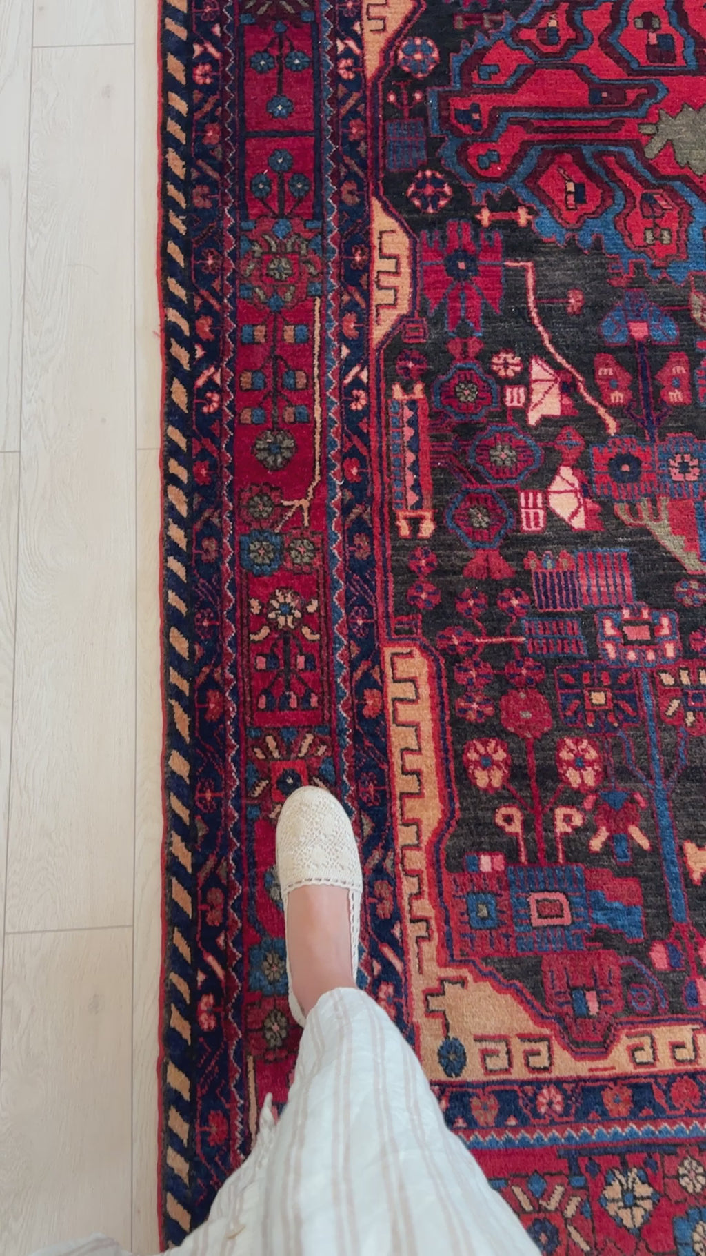 Close-up of foot stepping on Hand-Knotted Vintage Wool Area Rug – 10' 1" x 5' 5", highlighting the rug's fine wool texture and vivid border motifs.