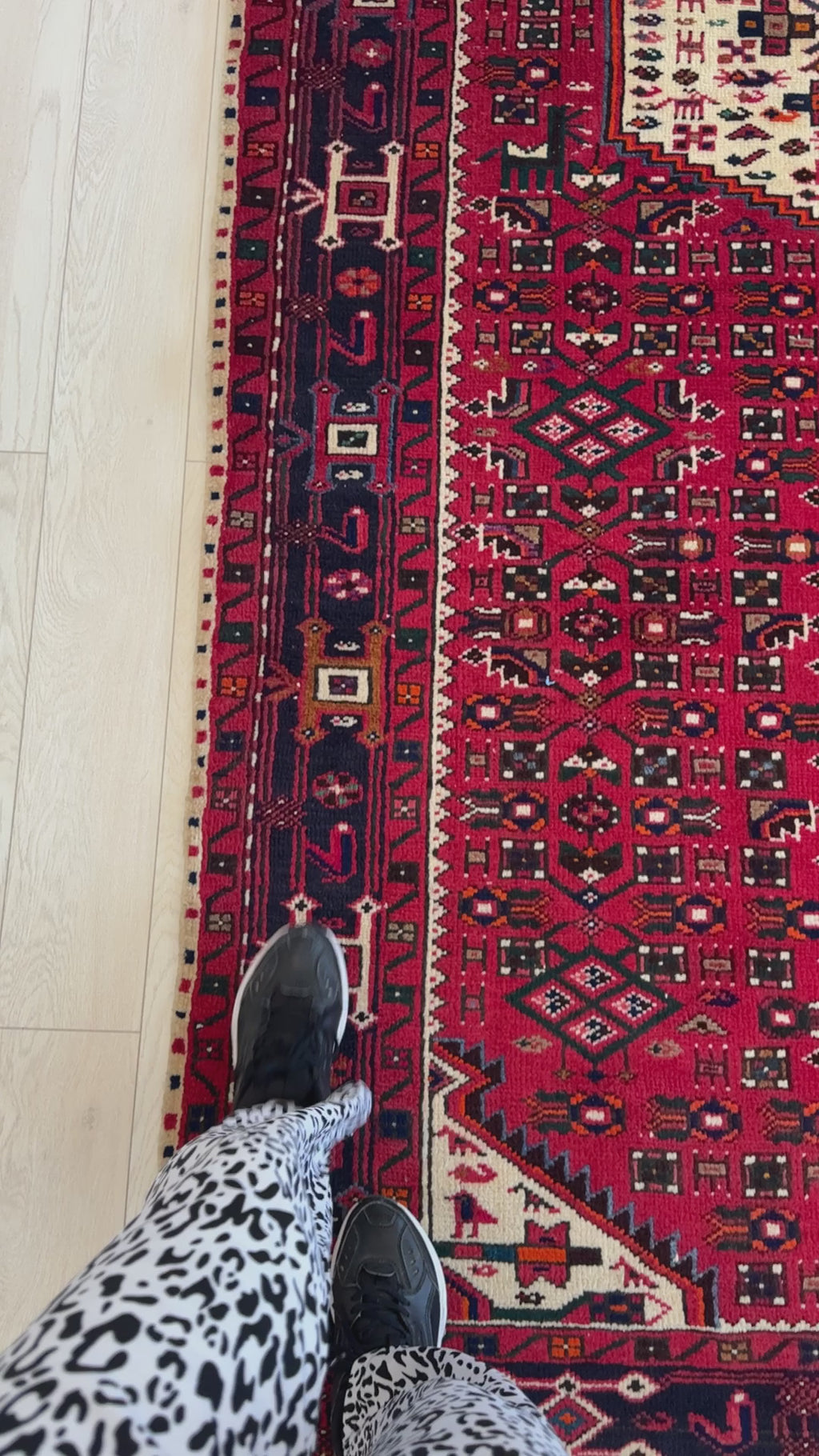 Close-up of Hand-Knotted Vintage Wool Area Rug – 10' 4" x 5' 3" showing detailed border design and scale with person standing on edge.