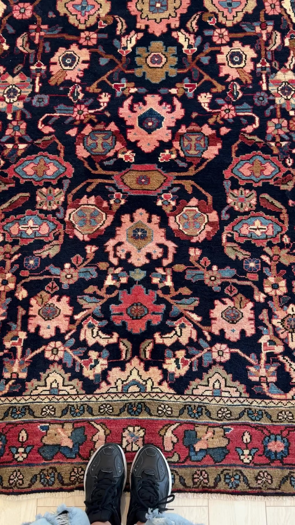 Close-up view of Hand-Knotted Vintage Wool Area Rug – 10' 8" x 5' 5" showing detailed floral motifs and deep navy background with red and beige accents.