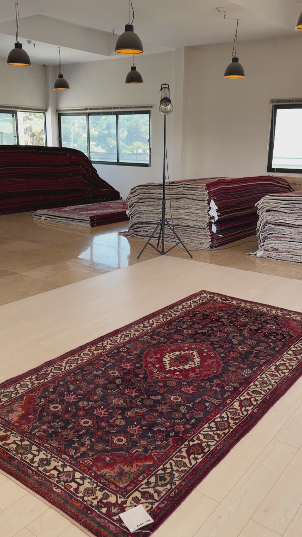 Hand-Knotted Vintage Wool Area Rug – 10' x 5' displayed in a showroom with natural lighting, emphasizing its rich colors and traditional design.