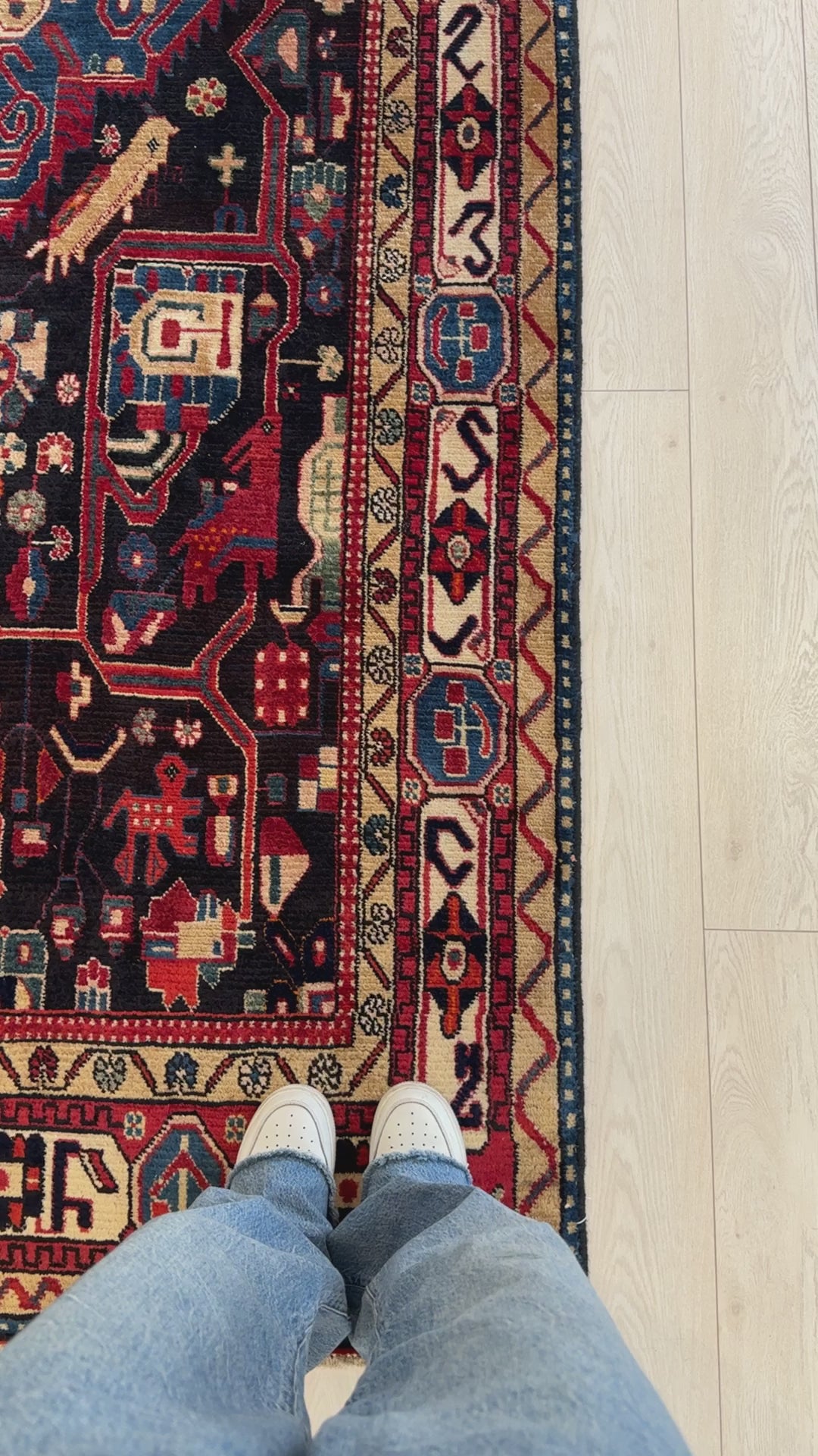 Close-up of border design on hand-knotted vintage Persian navy blue soft 5x10 tribal rug showing detailed patterns and vibrant colors.