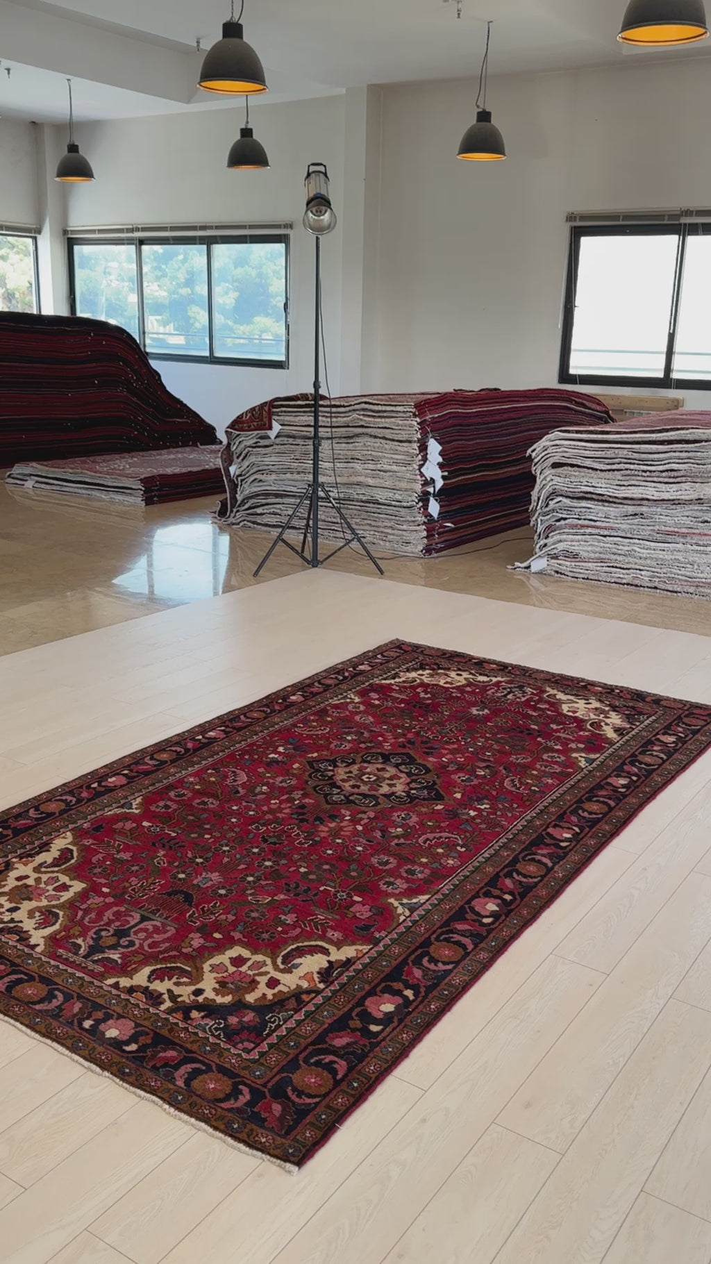 Hand-Knotted Vintage Wool Area Rug – 9' 8" x 5' 2" laid flat in a spacious showroom, highlighting its detailed floral motifs and rich red background.